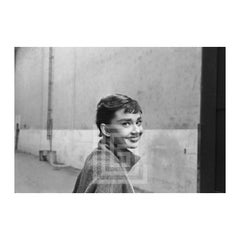 Audrey Hepburn con jersey de cuello alto gris, Miradas a la derecha sonriendo, 1953