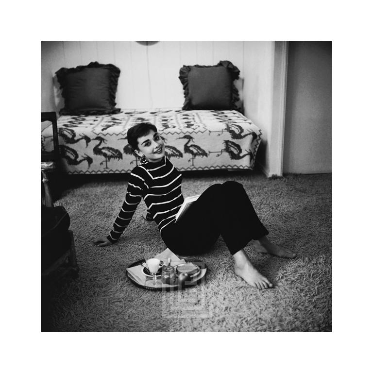 Mark Shaw Portrait Photograph - Audrey Hepburn in Striped Sweater Lounges, Arms Back, Smiling, 1953