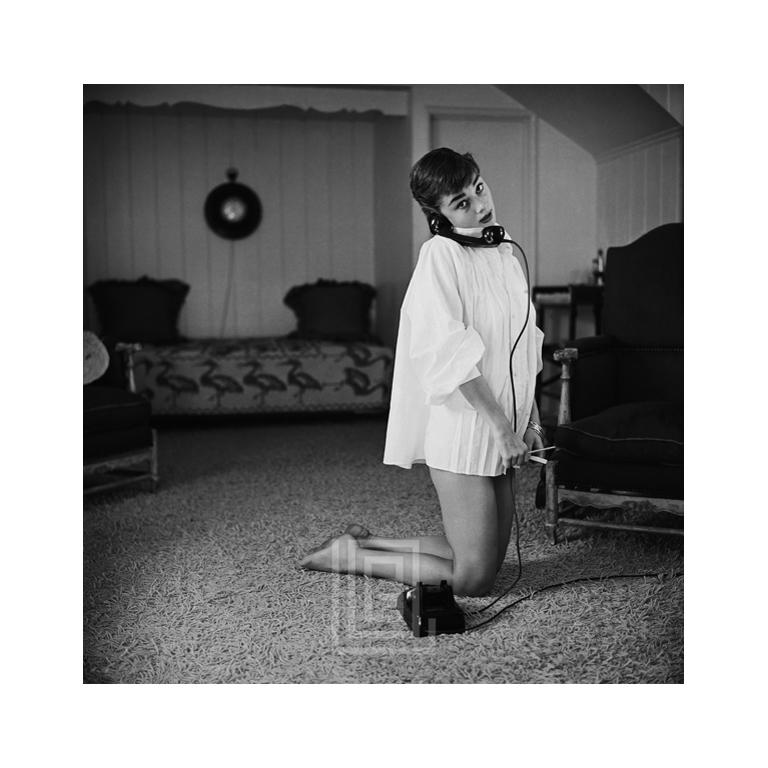 Mark Shaw Portrait Photograph – Audrey Hepburn in weißer Bluse mit Telefon, knitternd, 1953