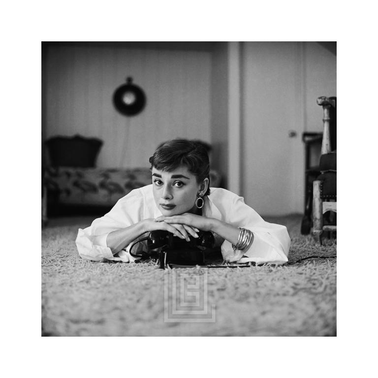 Black and White Photograph Mark Shaw - Audrey Hepburn en chemisier blanc avec téléphone, allongée, debout et se reposant sur un chinois, 1953