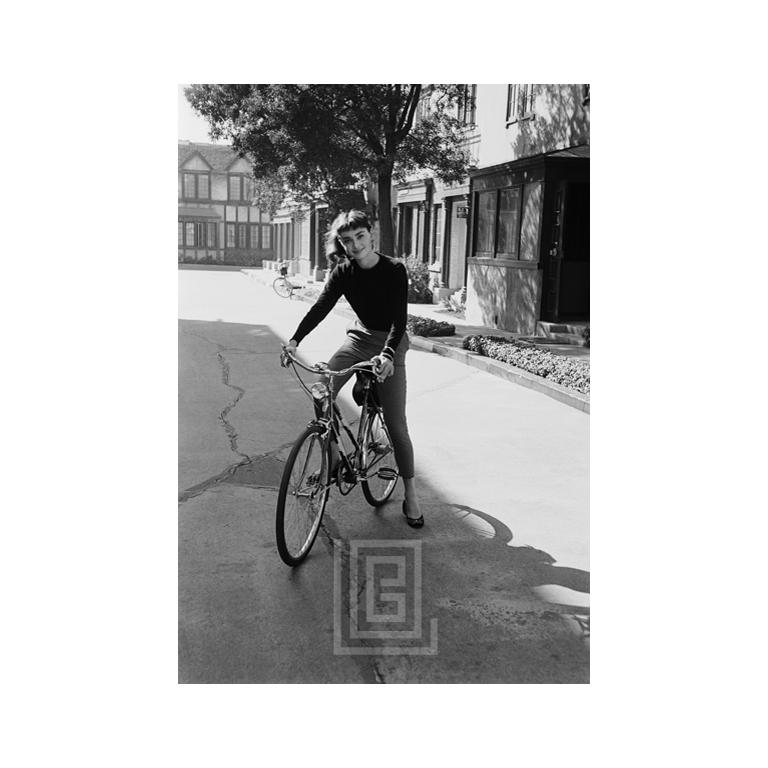 Mark Shaw Portrait Photograph – Audrey Hepburn auf Fahrrad, schüttelnd, 1953