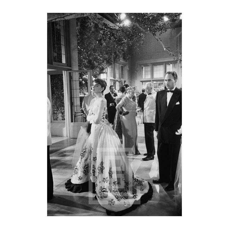 Mark Shaw Black and White Photograph - Audrey Hepburn Stands in Ballgown, 1953