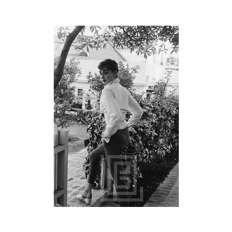 Mark Shaw Black and White Photograph - Audrey Hepburn strolls in front of her Beverly Hills apartment, Closer View