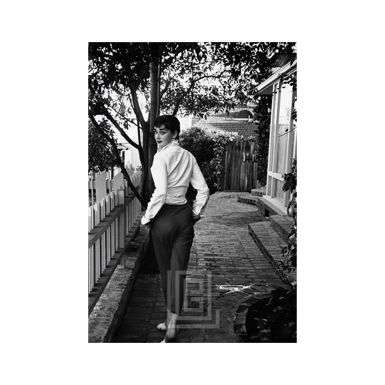 Mark Shaw Portrait Photograph - Audrey Hepburn Walking Away and Looking Back, 1953