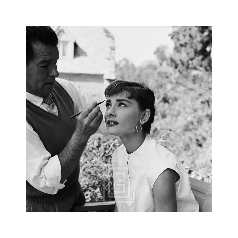 Black and White Photograph de Mark Shaw - Audrey Hepburn, Wally Westmore en el plató de Sabrina, Looking Up, 1953