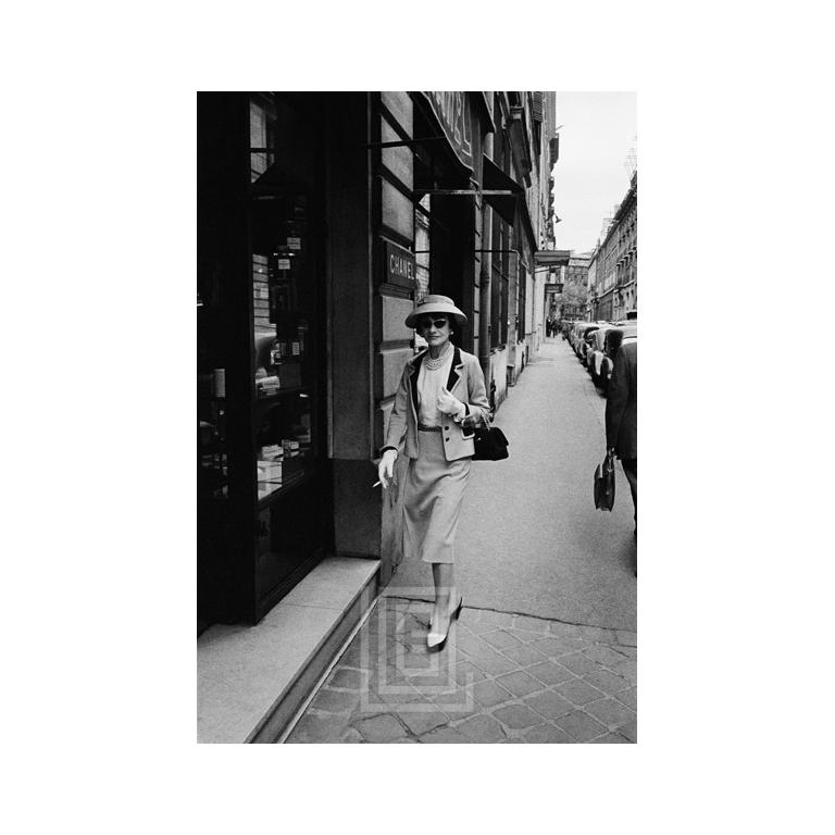 Mark Shaw Black and White Photograph - Coco Chanel Enters Her Paris Boutique, 1957