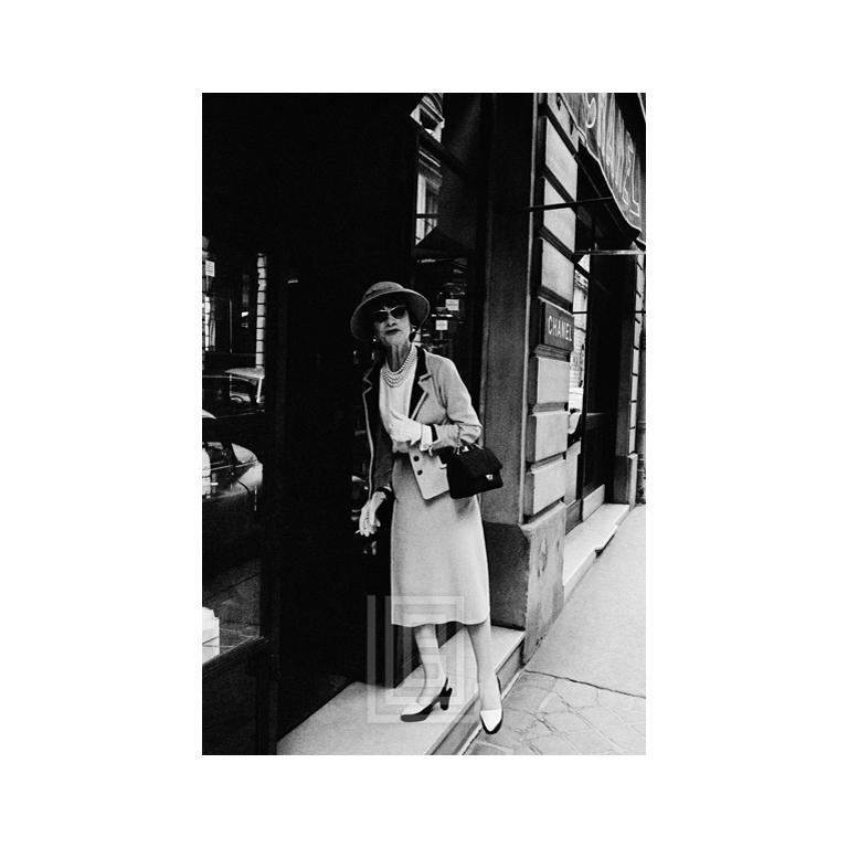 Mark Shaw Figurative Photograph – Coco Chanel betritt ihr Geschäft in der Rue Fauborg St. Honore, 1957