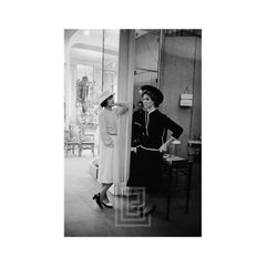 Coco Chanel con Suzy Parker en traje oscuro, 1957