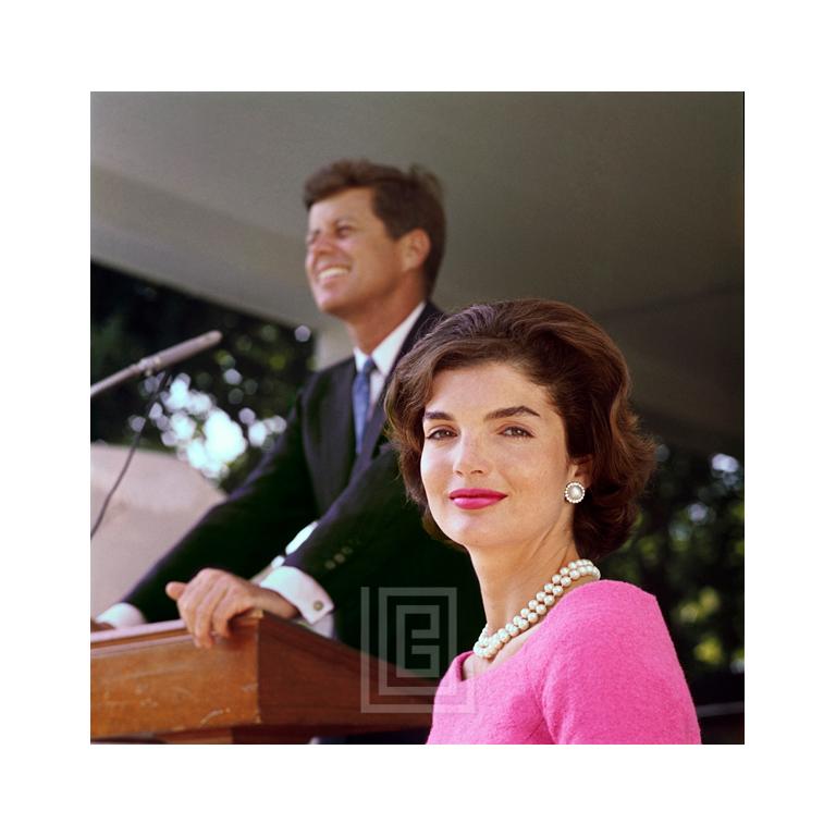 Mark Shaw Color Photograph – Kennedy Kennedy, Jackie in rosa Kleid, John at Podium