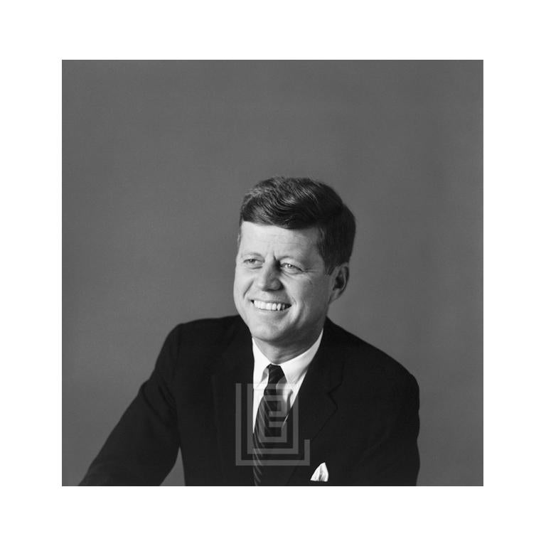 Kennedy, portrait de John F., épaule gauche devant, souriant, 1959