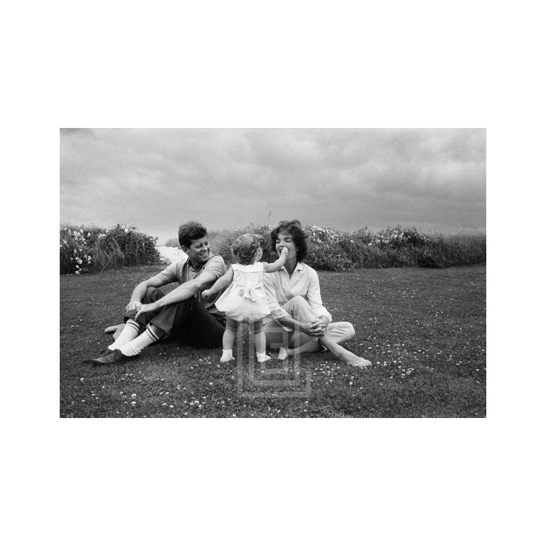 Mark Shaw Figurative Photograph - Kennedys, Caroline Feeds Flower to Jackie, John Looks on, 1959