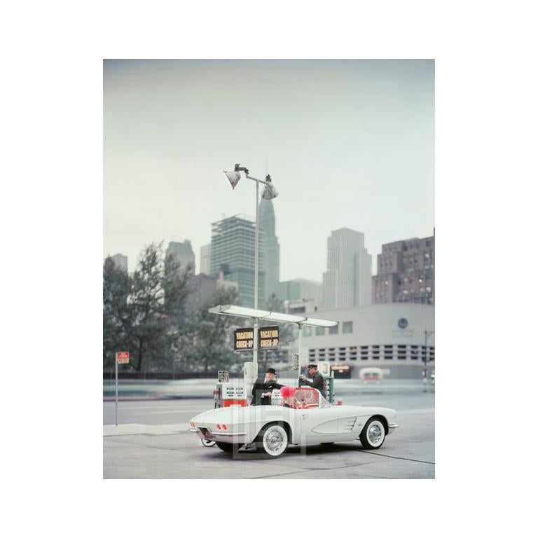 Mark Shaw Figurative Photograph – Weiße Corvette in Gasstation, Tag, ca. 1960
