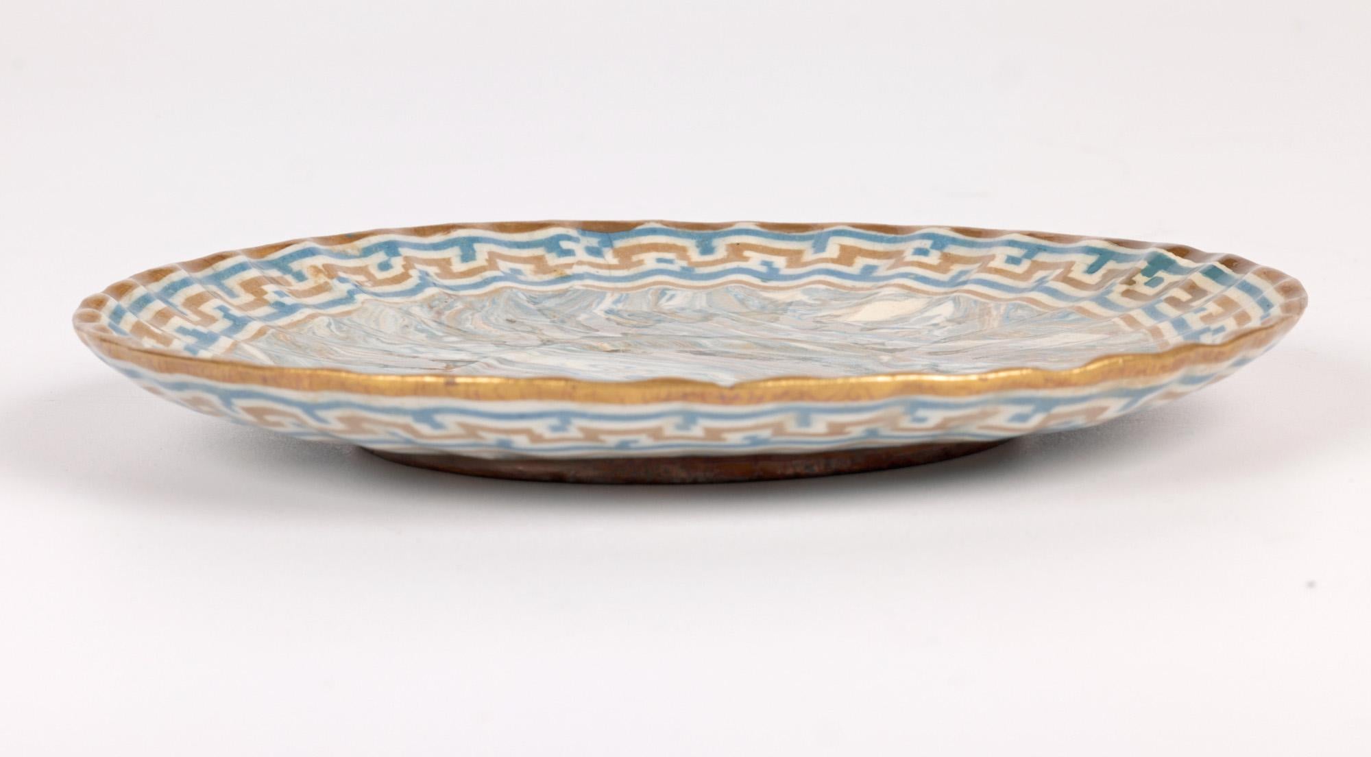 A very rare and stylish Doulton Lambeth Marqueterie Ware blue and brown marbled art pottery saucer with gilded designs by Lambeth’s first Art Director Wilton Parker Rix (Doulton Lambeth 1868-1897) and dating from around 1887. 
Rix became a trainee