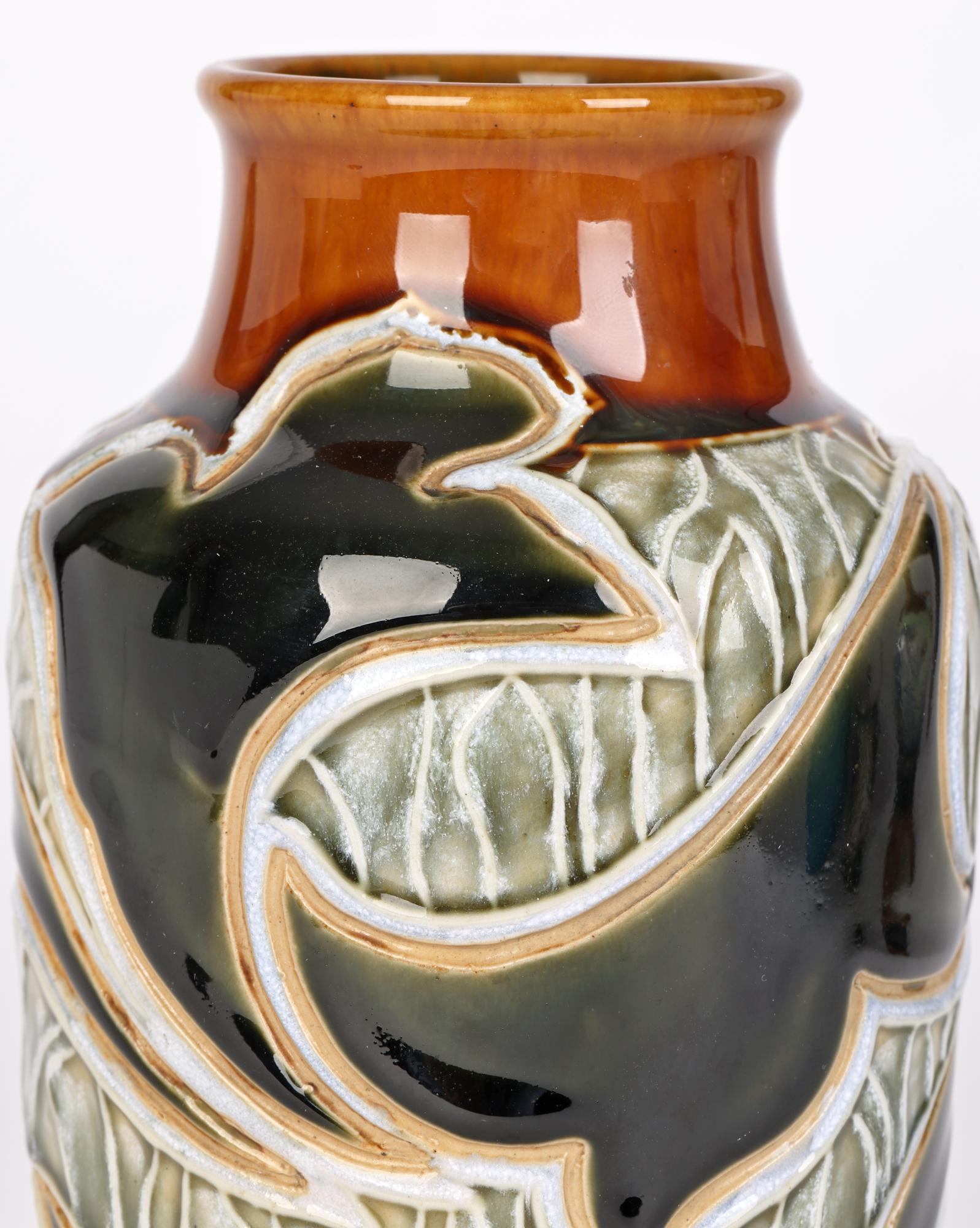 A stylish Doulton Lambeth Art Nouveau vase with abstract leaf designs by renowned and sought after artist Mark V Marshall dated 1905. The stoneware vase is of simple tall bulbous shape standing on a narrow unglazed foot and is decorated with incised