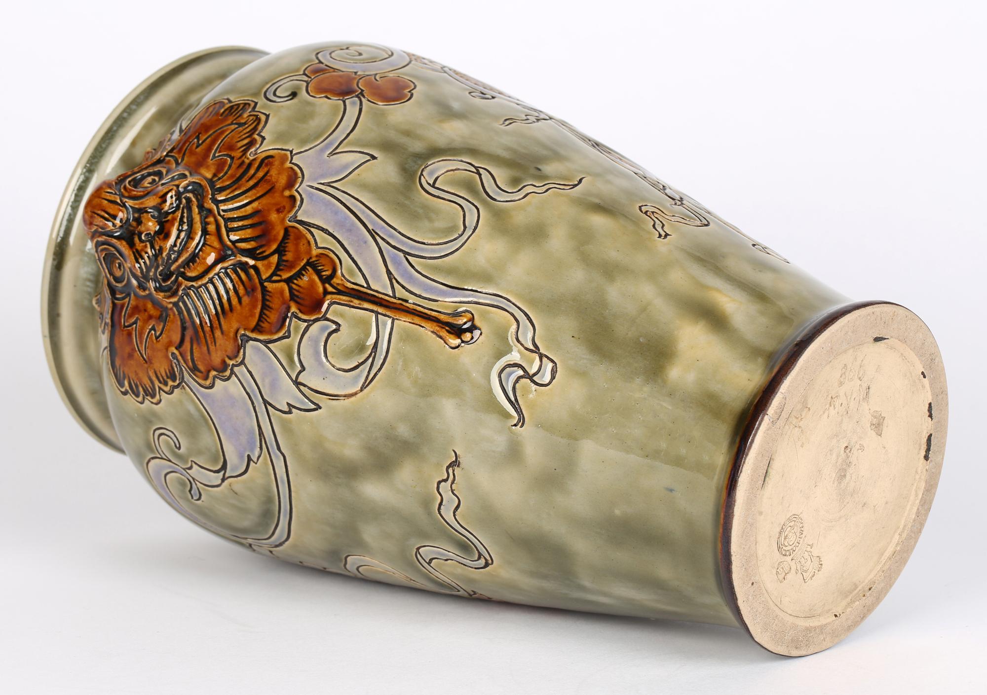 Un rare et étonnant vase Doulton Lambeth Art Nouveau décoré de masques grotesques de style gothique par Mark V Marshall et daté de 1907. Le grand vase en grès, de forme bulbeuse arrondie, est décoré en relief de deux masques grotesques à glaçure