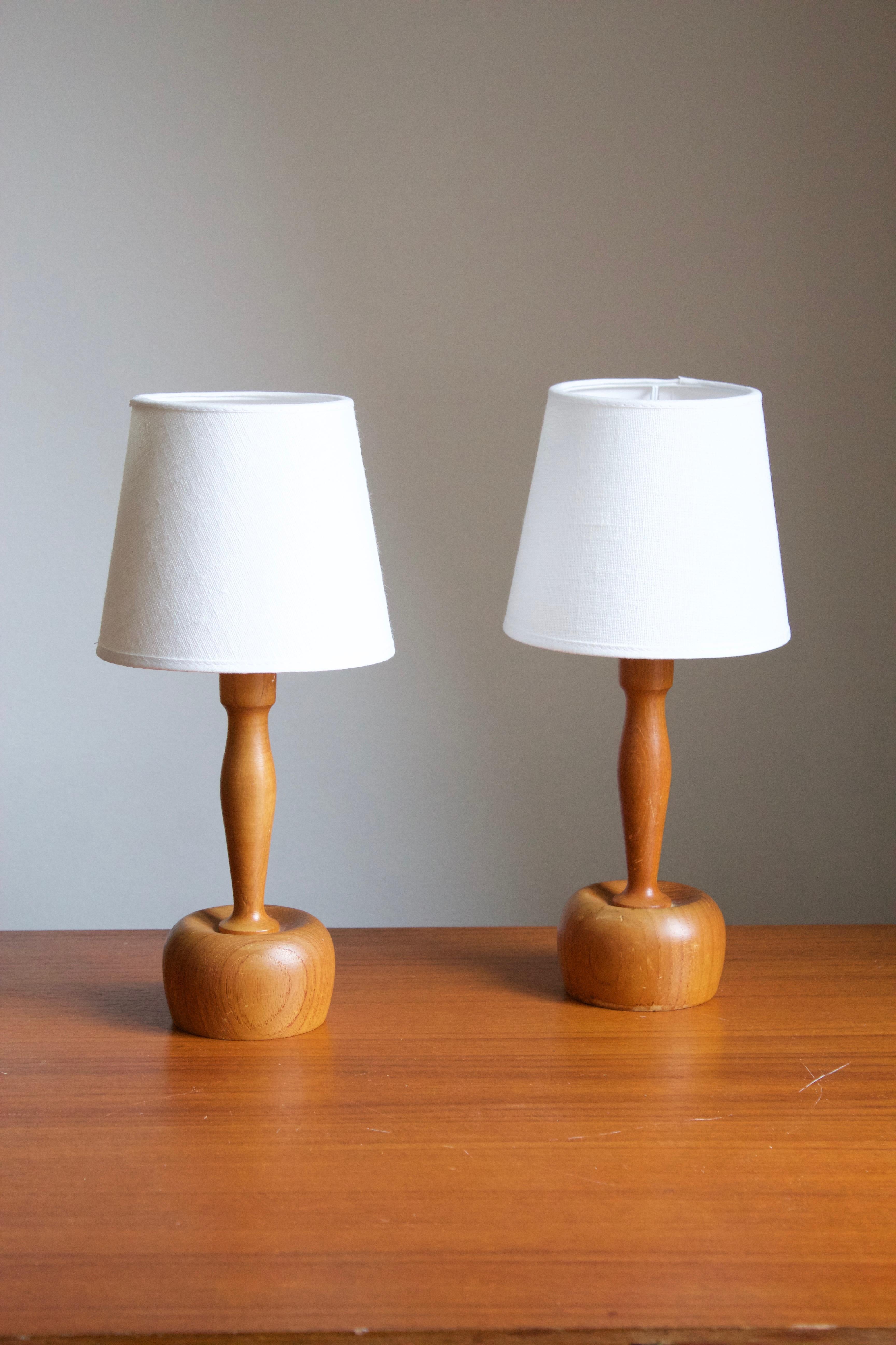 A pair of sizable table lamps. In solid pine. Brand new lampshades. Produced by Markslöjd, Kinna, Sweden, c. 1970s. Marked.

Stated dimensions include linen lampshades. Measured as illustrated in first image. Sold without lampshades.