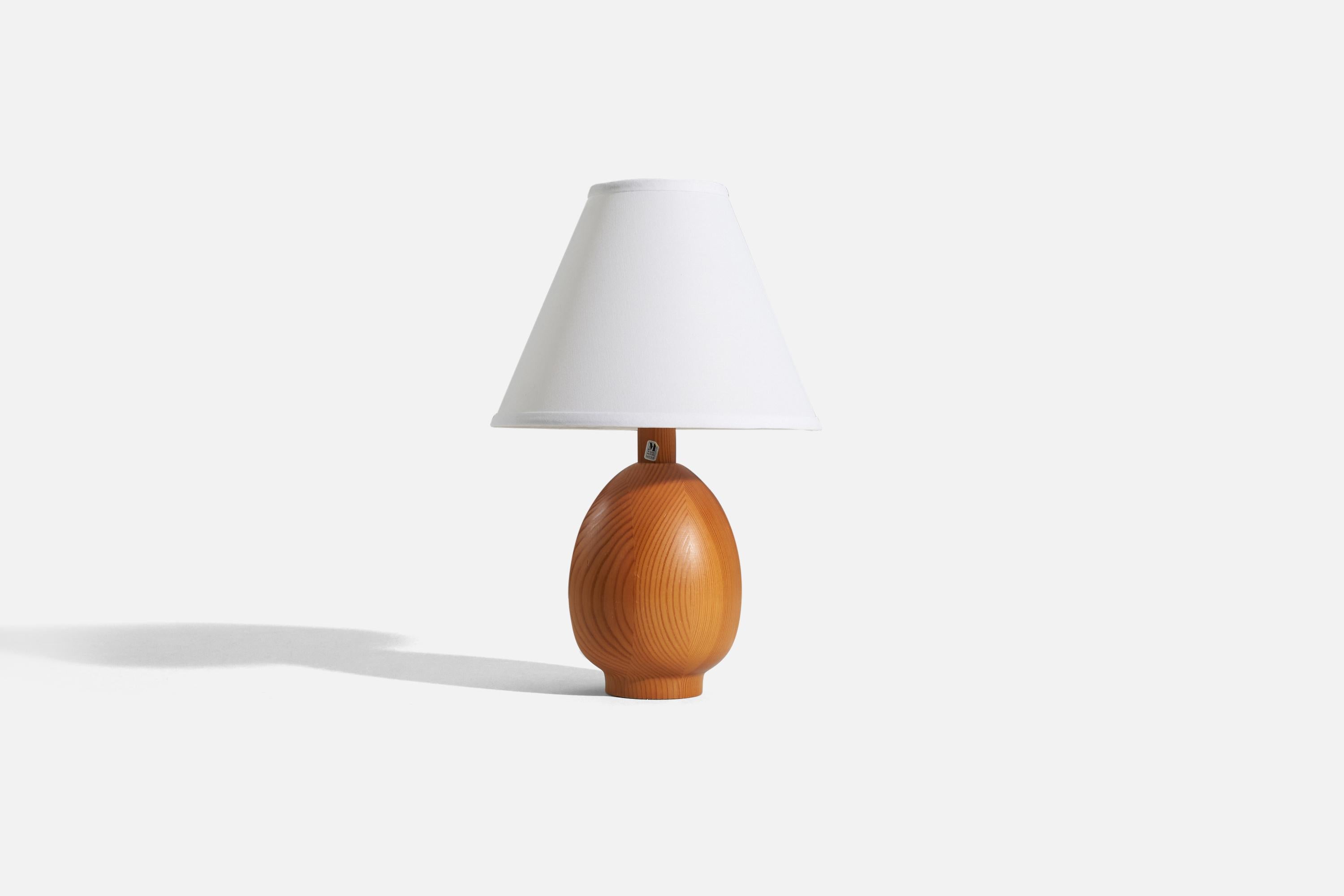 A solid pine table lamp designed and produced by Markslöjd, Kinna, Sweden, c. 1970s.

Sold without lampshade. 
Dimensions of Lamp (inches) : 11.3125 x 5 x 5 (H x W x D)
Dimensions of Shade (inches) : 4.25 x 10.25 x 8 (T x B x H)
Dimension of