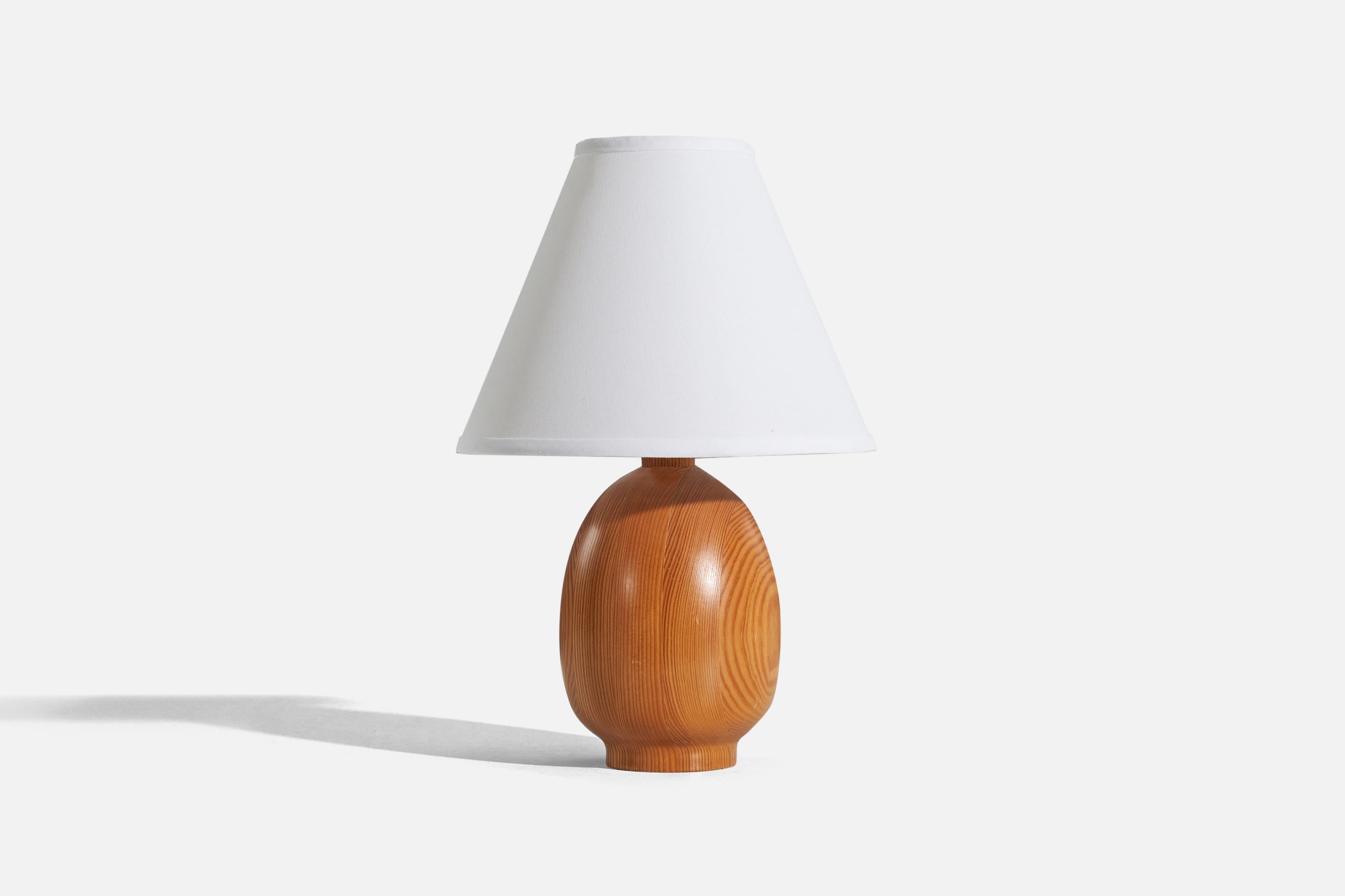 A solid pine table lamp designed and produced by Markslöjd, Kinna, Sweden, c. 1970s.

Sold without lampshade. 
Dimensions of Lamp (inches) : 11.3125 x 5.375 x 5.375 (H x W x D)
Dimensions of Shade (inches) : 4.25 x 10.25 x 8 (T x B x