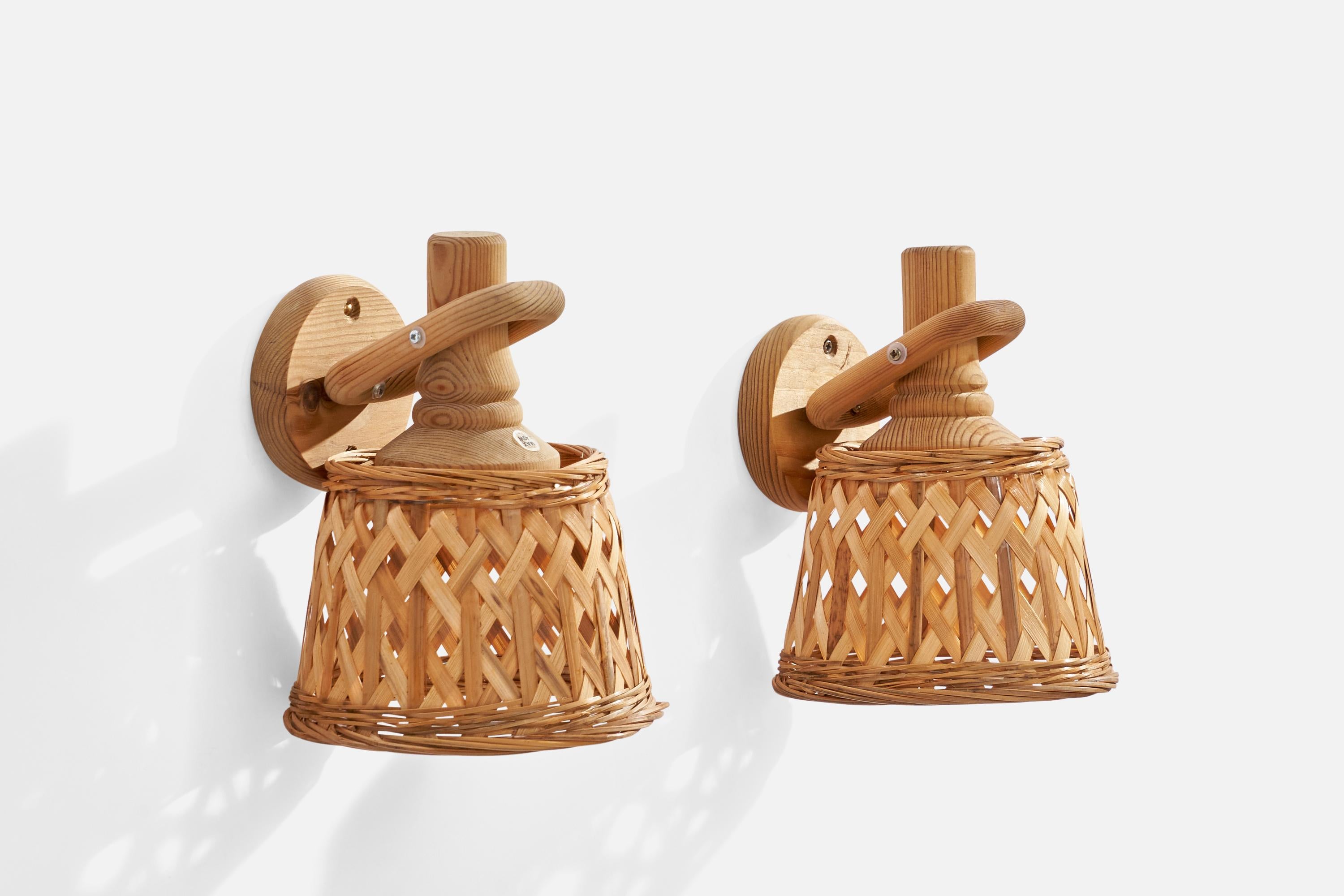 A pair of pine and rattan wall lights designed and produced by Markslöjd, Sweden, c. 1970s.

Please note cord runs from backside of wooden socket, running visibly along the fixture.

Overall Dimensions (inches): 8” H x 6.35” W x 7.5” D
Back Plate