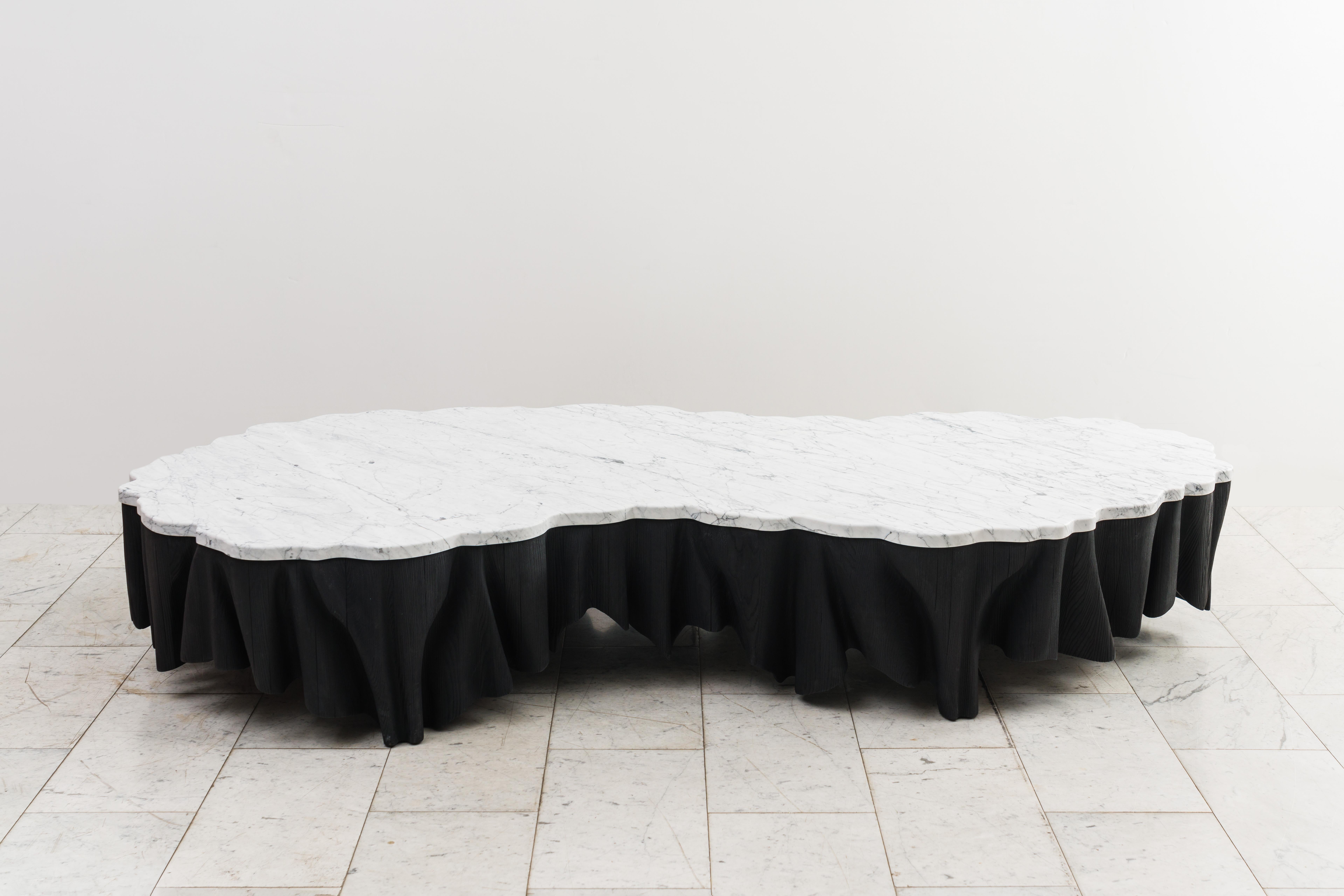 Der Tisch Aeolian von Haase ist von den Wellen des vom Wind verwehten Sandes inspiriert und verkörpert den besonderen Ansatz des Bildhauers, Stein und Holz fließend miteinander zu verschmelzen. Die jahrzehntelange Erfahrung des Künstlers als