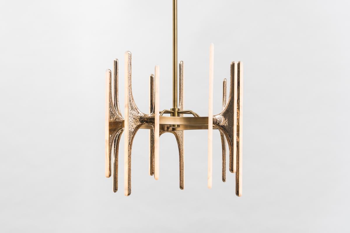 Inspired by nature and the human form, Markus Haase’s Sculptural Series sconces and chandeliers are composed of bronze or wood asymmetrical butterfly forms. Each hand carved form is embedded with white onyx, encasing dimmable LED lights, offering a