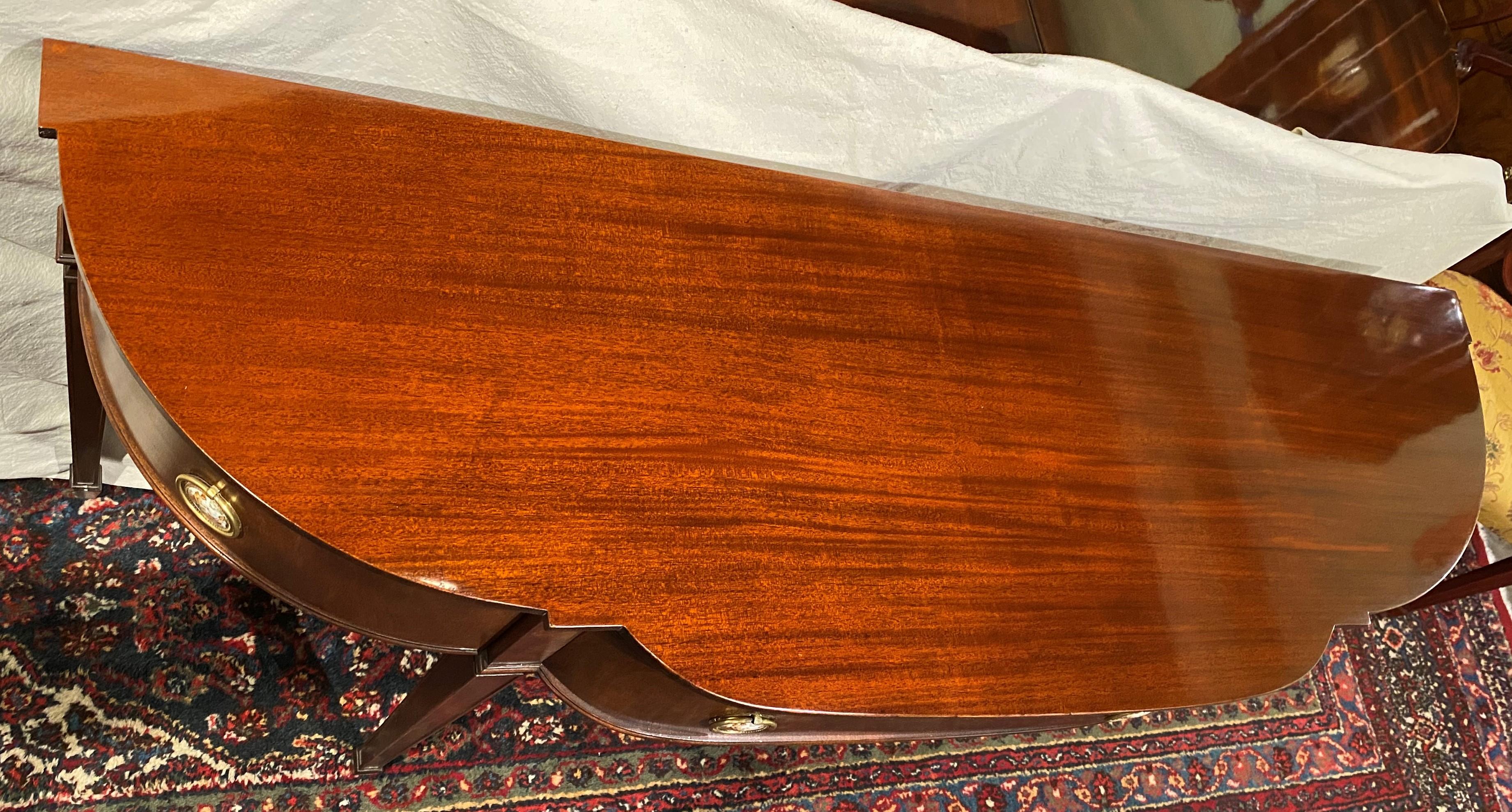 A finely made mahogany console table or server in the Hepplewhite style manufactured for the Marlboro Manor furniture line of H. Sacks & Sons, Brookline, MA. The case has a single center frieze drawer flanked by two conforming doors, opening to
