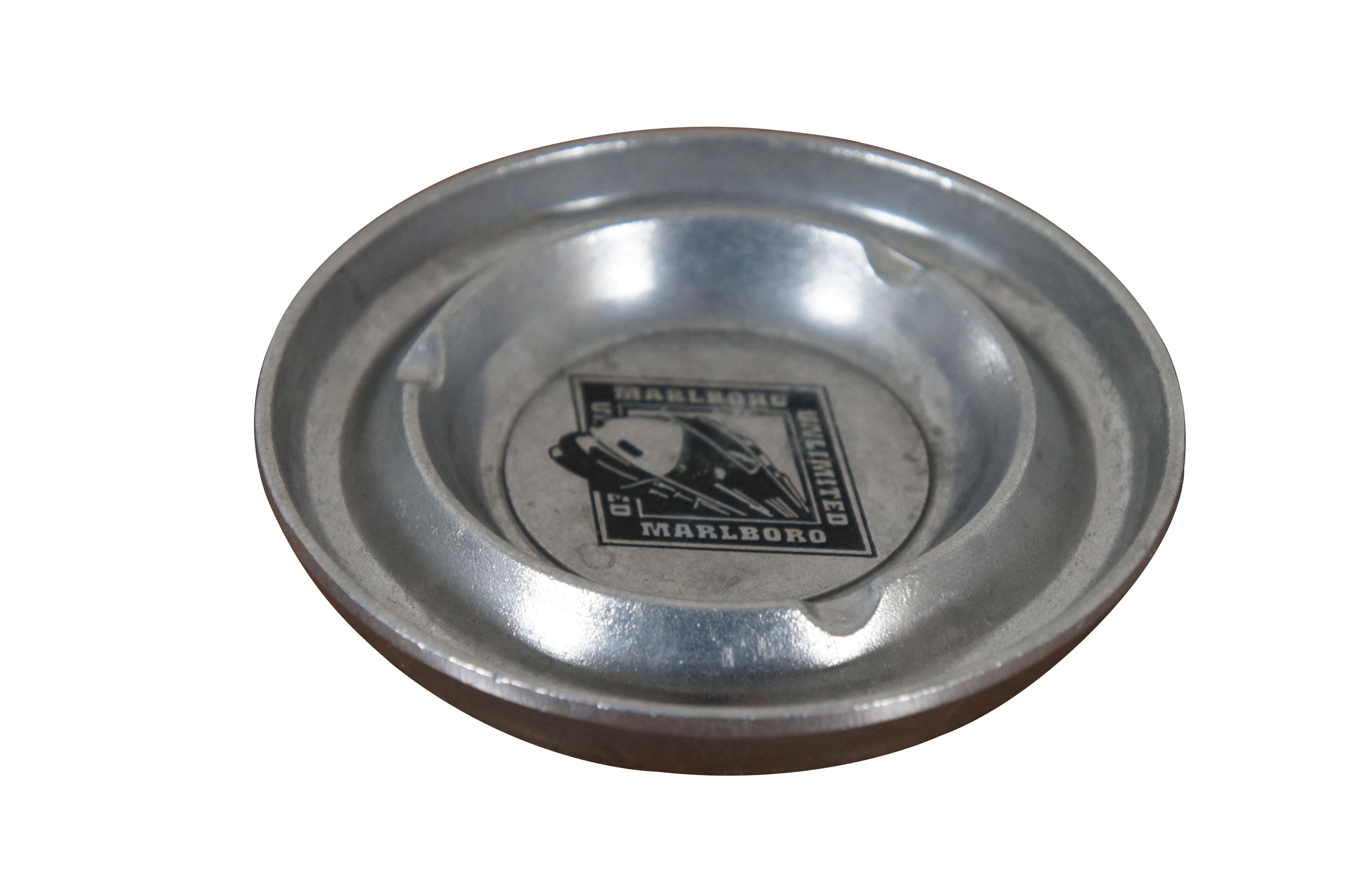 Vintage Marlboro Unlimited cast aluminum advertising ashtray featuring a round form with three cigarette rests and Marlboro Unlimited train engine design in black at the center. 

Dimensions:
5.25
