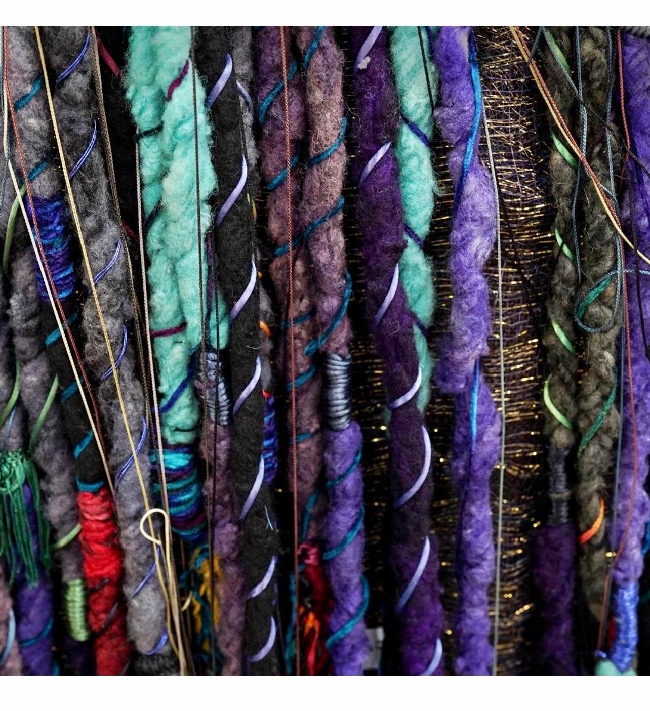 Eclectic, mixed media wall hanging textile tapestry by Marlene (Marlen) Richard featuring abstract embroidery atop free hanging locks of fabric over a black background embellished with gilt fabric accents. Hand made and hand embroidered.  This had a