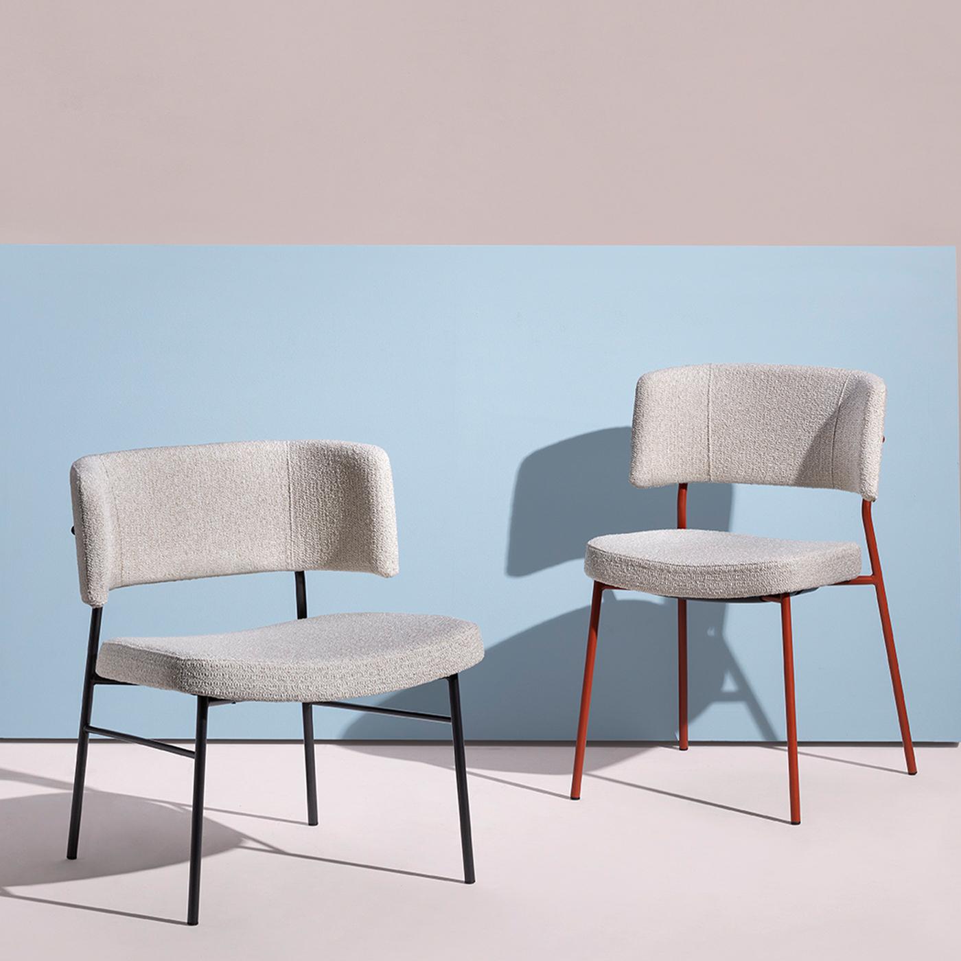 Feeling spoiled even when sitting in a contract space is the experience this lounge chair promises at first glance through its enveloping and ergonomic design. Despite the rigor of its thin black-lacquered metal structure, the curved seat and