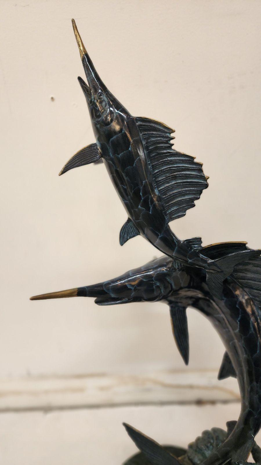 Sculpture en bronze d'un espadon avec un plus petit poisson sautant hors de l'eau.
Estampillé de la mer de fonderie.