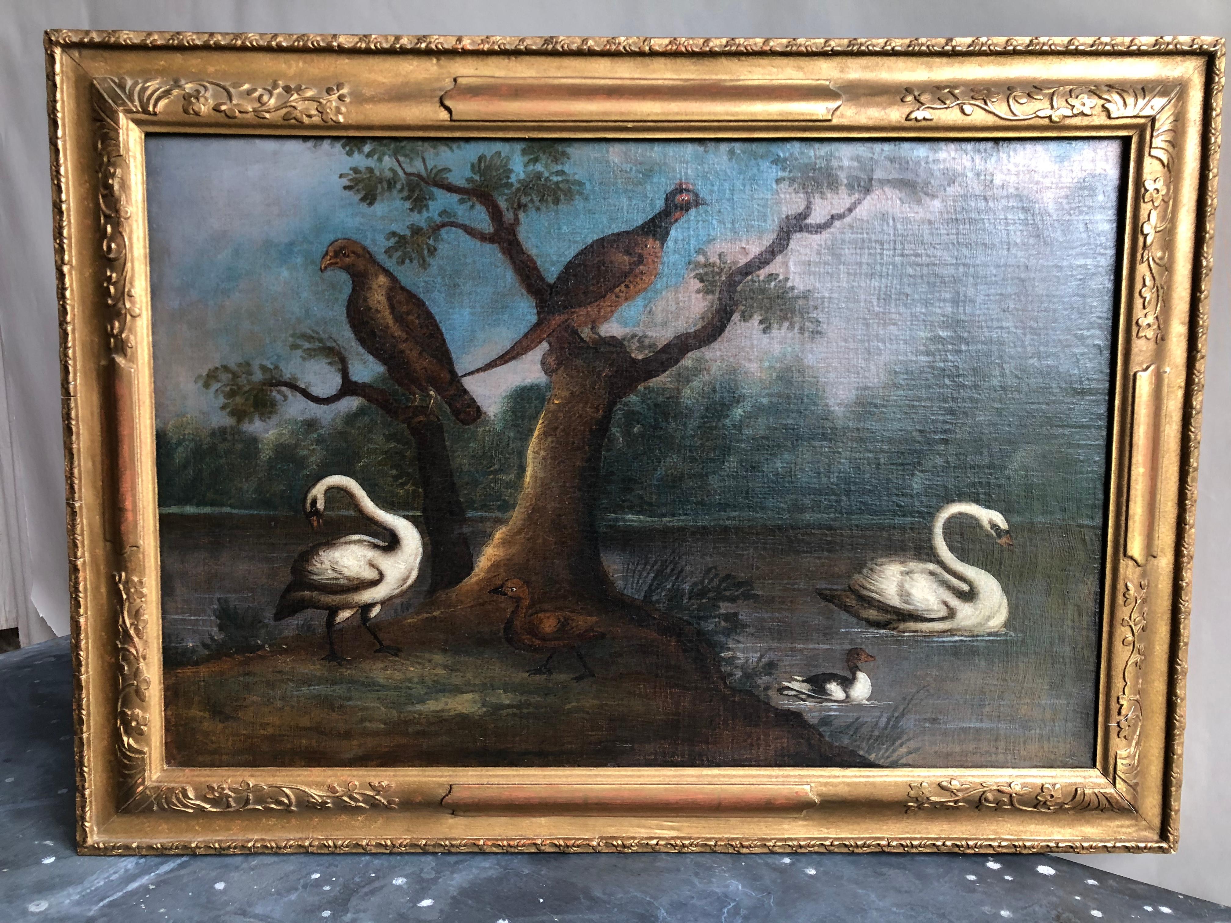 An oil-on-canvas scene of swans and other birds in a pond, in the style of Marmaduke Cradock, 18th century. In a contemporary giltwood frame. Canvas size- 30” W x 20” H.