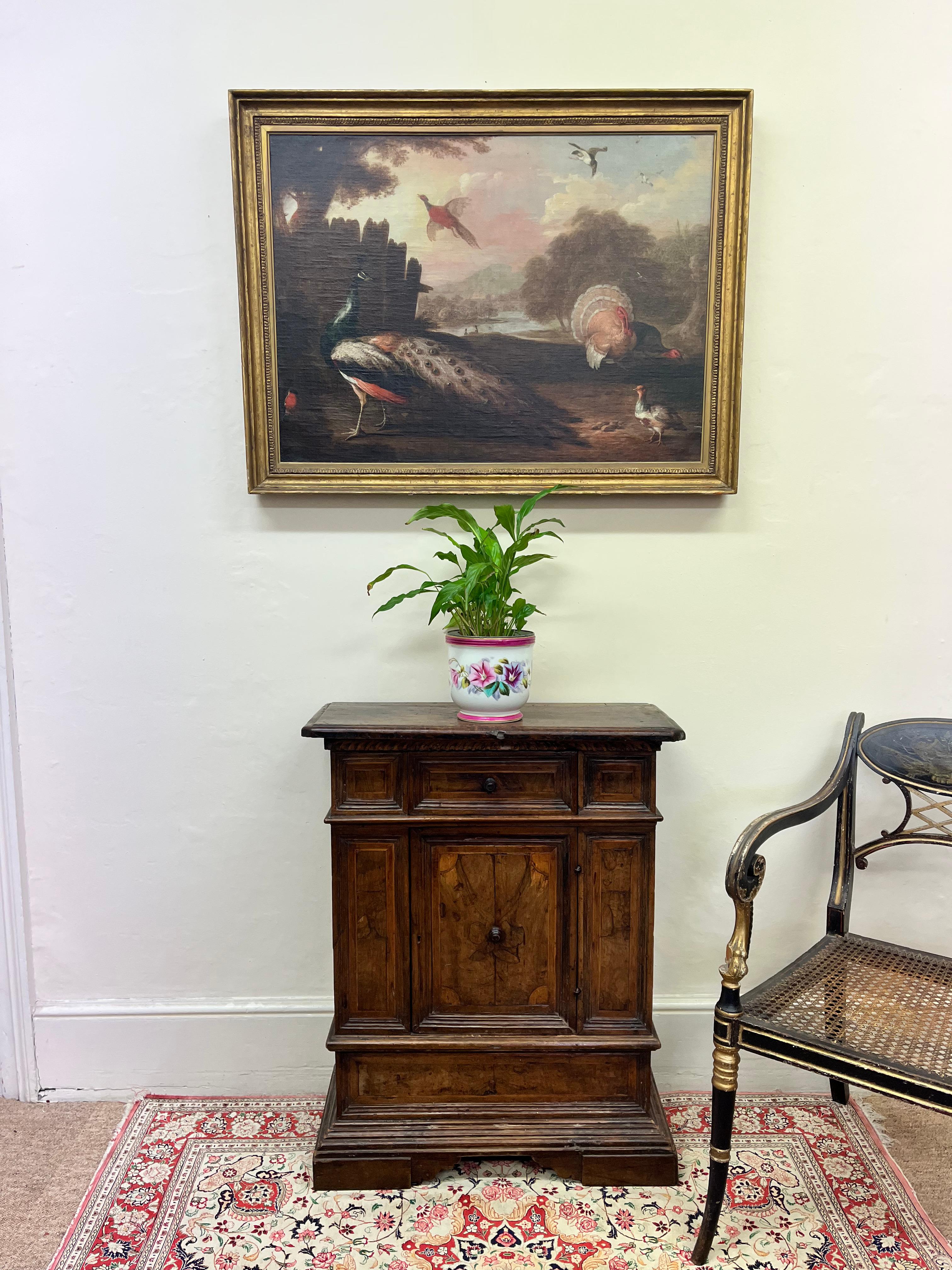 Raffigura un pavone, un fagiano, un tacchino e vari altri uccelli in una stravagante scena di campagna.
Con una firma indistinta,
In una successiva cornice in legno dorato modellata a uovo e dardo.
59 cm x 82,3 cm senza cornice 

