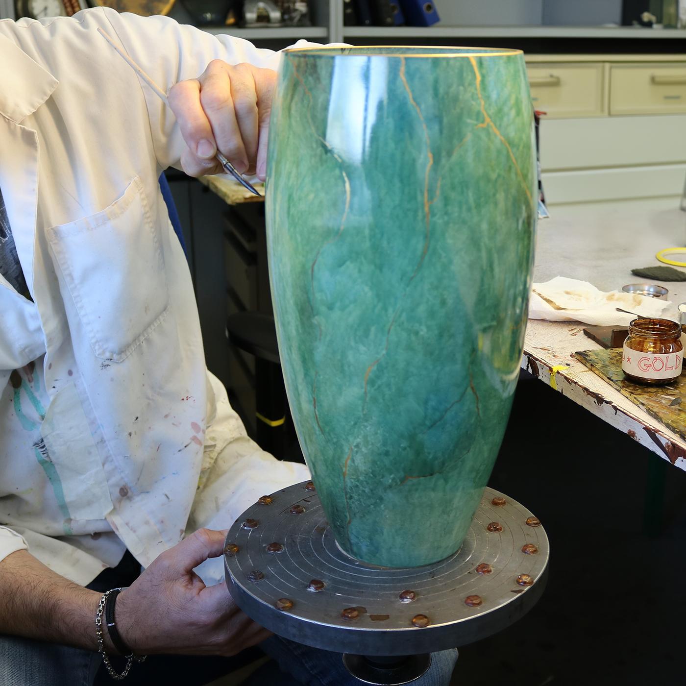 Questo squisito vaso presenta un corpo ovale allungato realizzato a mano in vetro con uno splendido aspetto marmoreo che farà la sua figura in qualsiasi arredamento. Il vetro verde smeraldo presenta sfumature cromatiche che ne esaltano i contorni ed