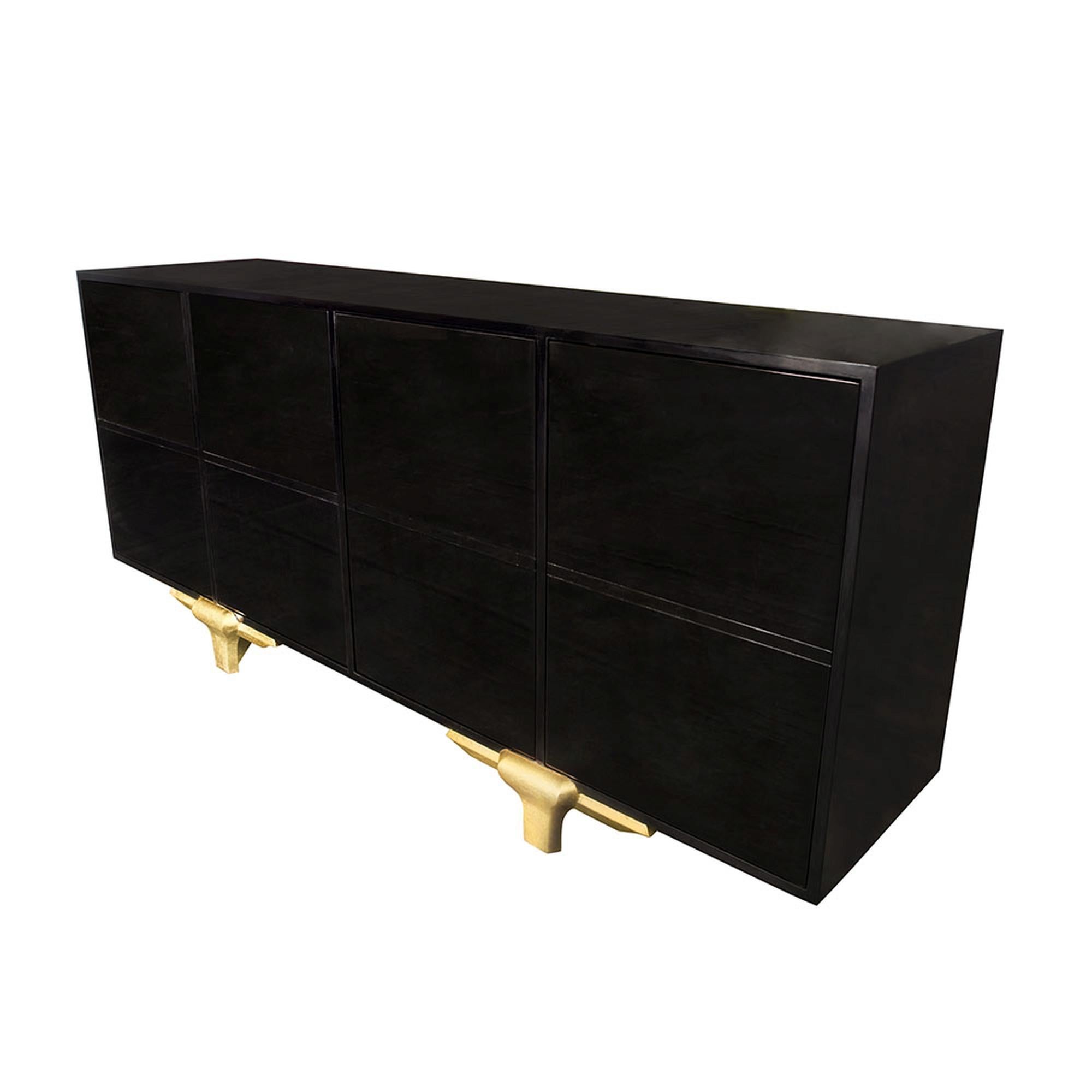 With its grand appeal, the Marmont buffet is a stunning, sophisticated piece. Its incredibly clean design makes the lacquered ebony wood look as if it is merely oating on the hand carved gold leaf legs. Every inch of this sleek design has been