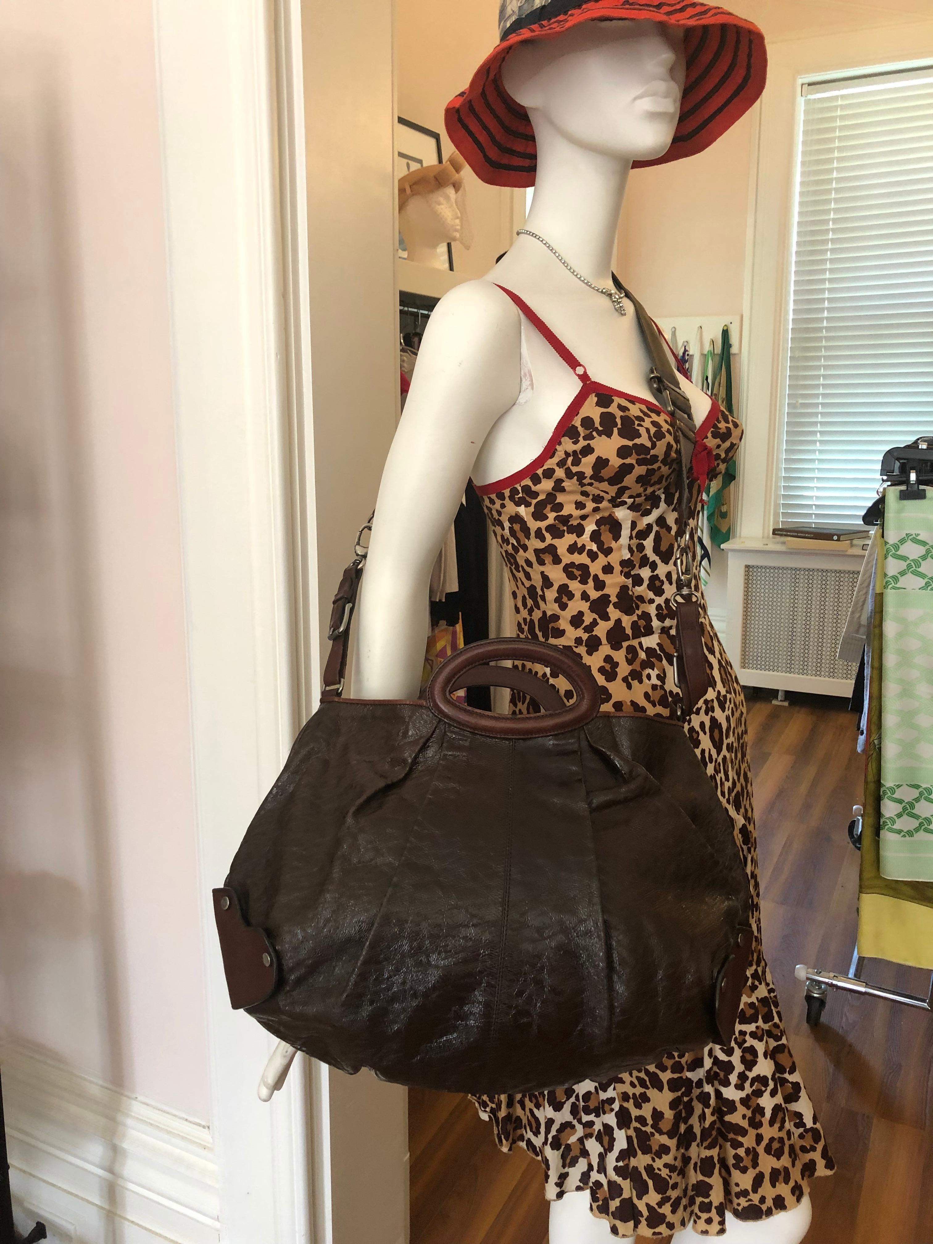 This Marni Baloon chocolate brown leather handbag is in excellent condition. It is soft sided with a detacheable crossbody strap, as well as two flat top handle straps.
The hardware is an antique silver tone; there is an inside as well as a large