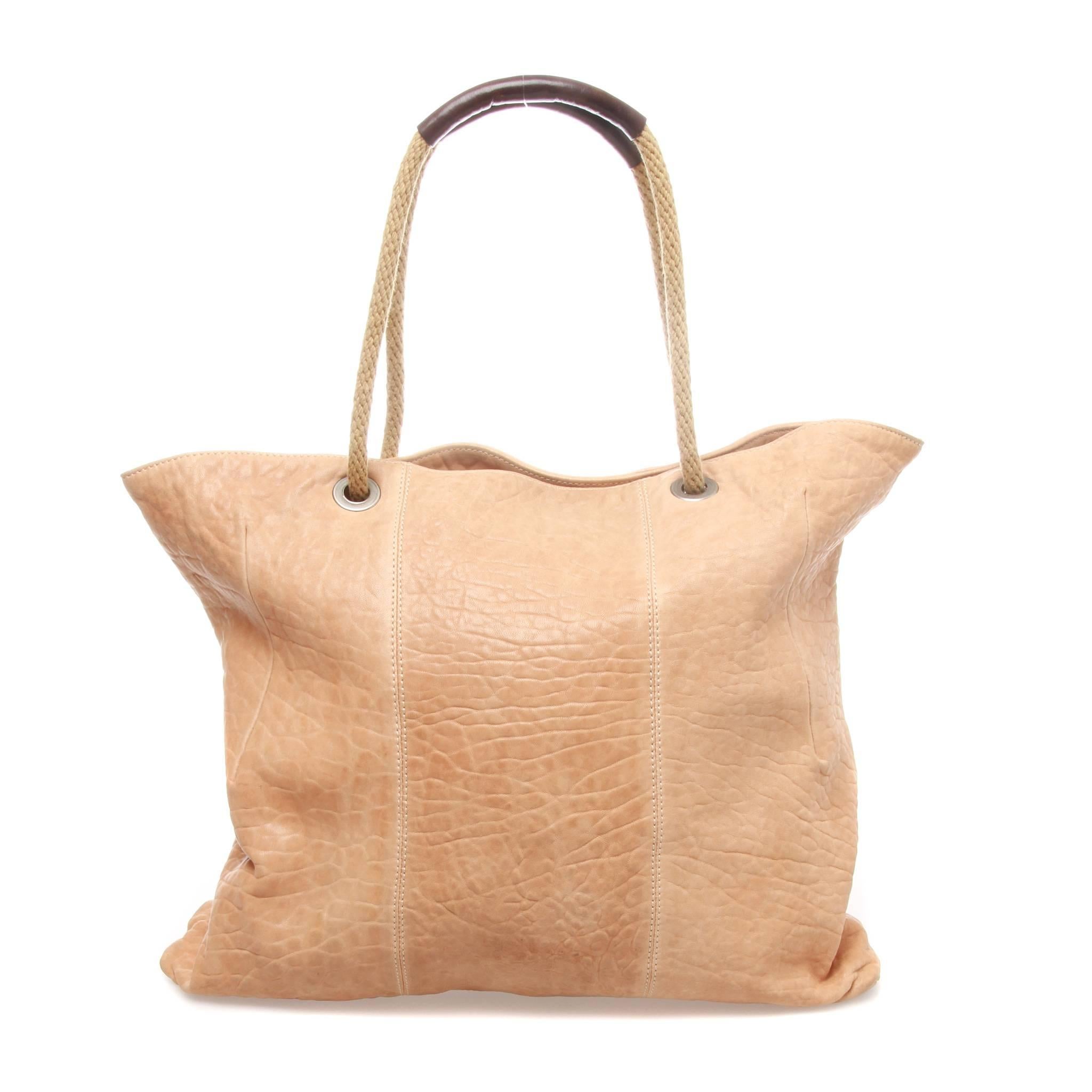 A multi-functional MARNI Beige Leather Shopping Tote.
A large tote features a rope and leather trim straps.
Interior with canvas lining consists of a pocket on both sides, one zipped and one without.