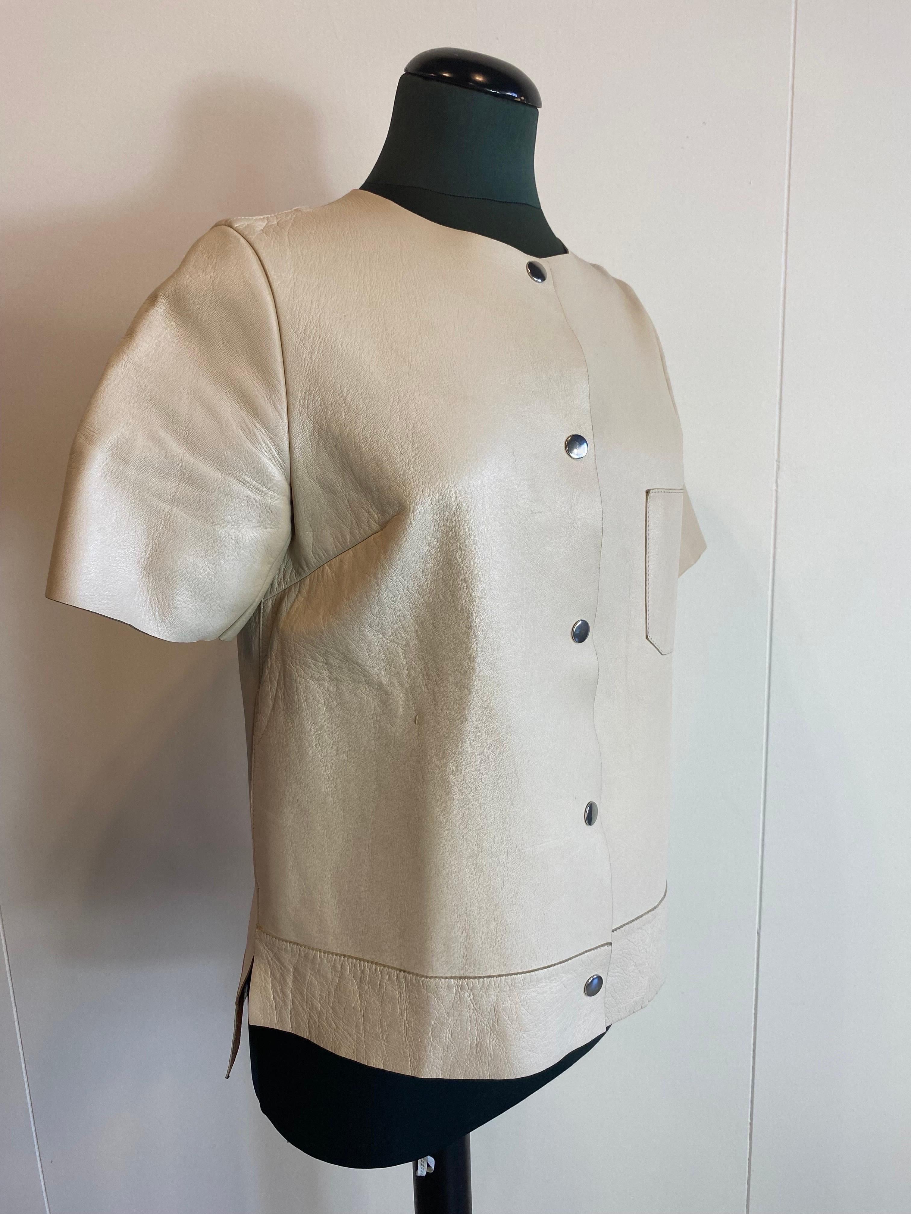 Marni beige leather short-sleeved jacket
Summer edition 2014. With pockets.
In leather. Duo color outside beige inside brown.
Slightly longer at the back. Square model.
Size 40.
Shoulder 39
Sleeve length 25
Length 64
Bust 51
In very good condition,