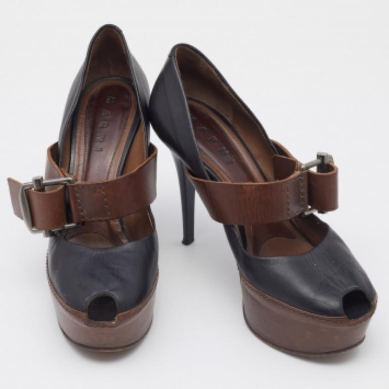 Stand tall and in style wearing this pair of gorgeous pumps from Marni. Crafted from black-brown leather, the fashionable pumps feature peep toes, sturdy platforms, buckled straps, and 12 cm heels. Team them with dresses and pants alike!