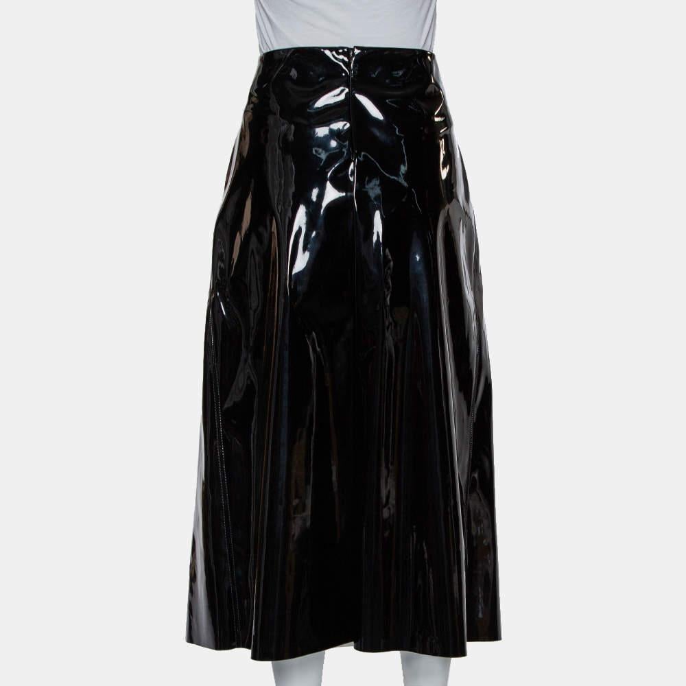 Wear a bold look with this Marni skirt in a gorgeous black hue. The piece comes crafted from faux patent leather, enhanced with contrasting hanging thread details, and falls to a midi-length. It is equipped with a zip closure. Wear it on your