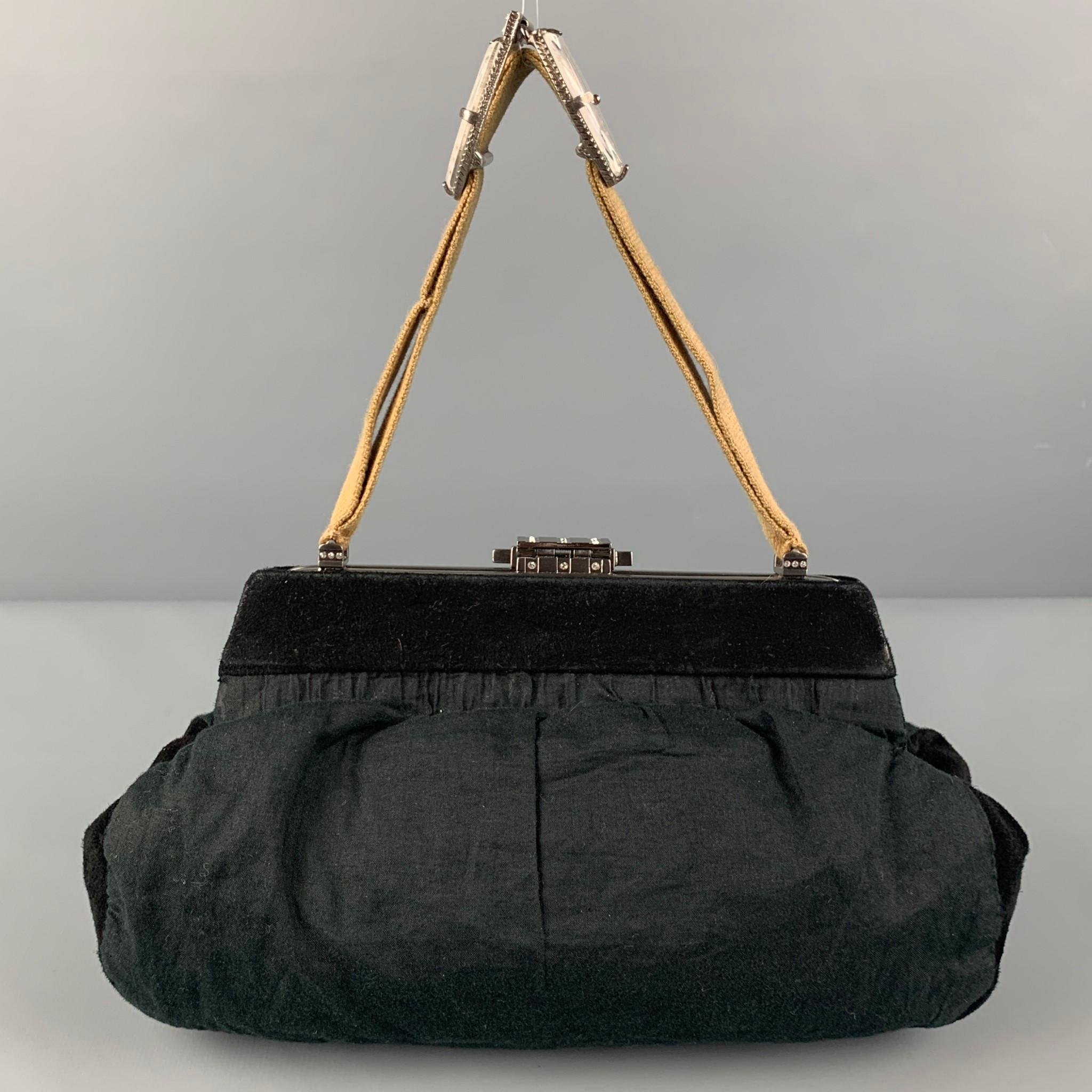 MARNI handbag comes in a black material with a suede trim featuring a large clasp detail, canvas top handles, inner pocket, and a push open closure. Made in Italy. 

Very Good Pre-Owned Condition.
Original Retail Price: