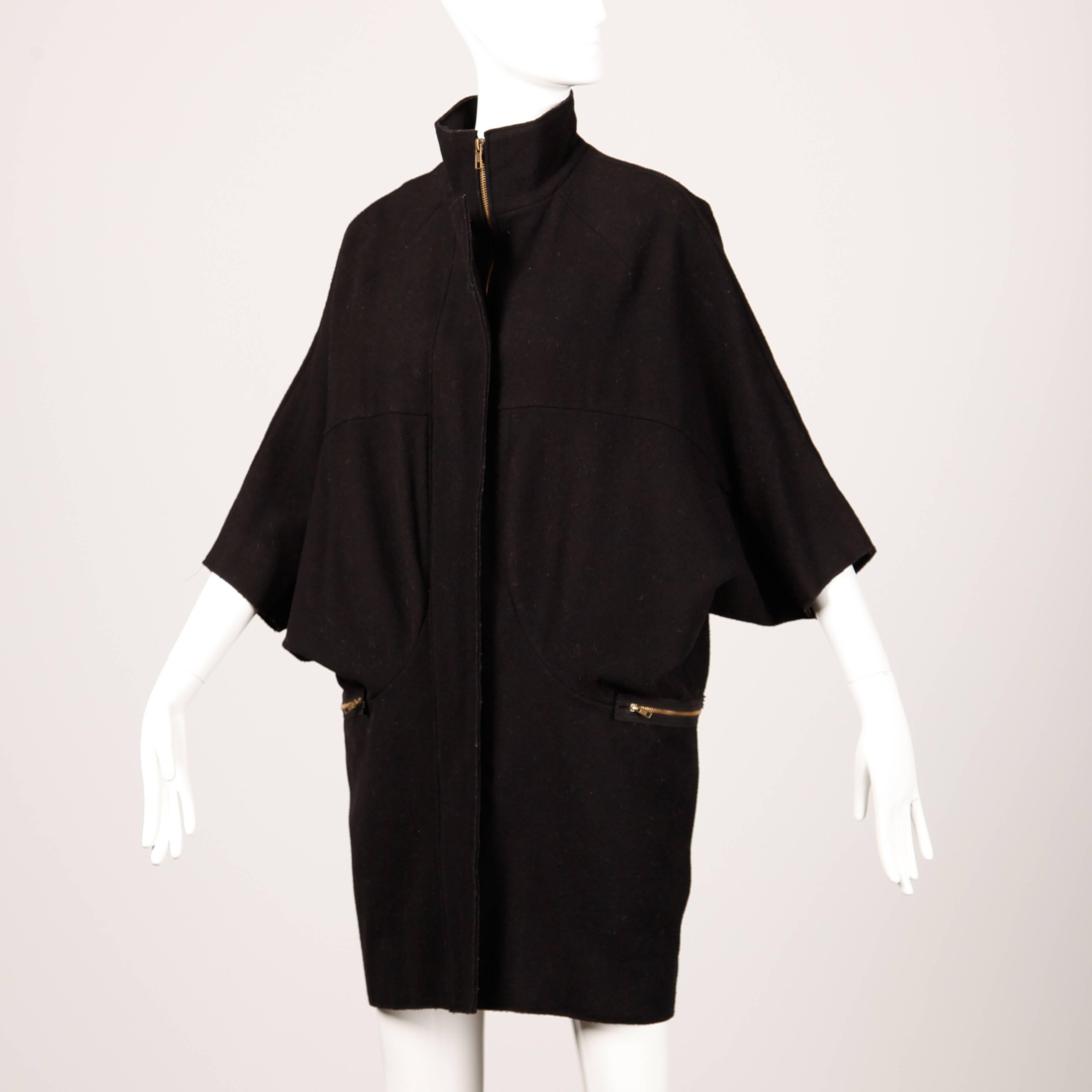 Chic black wool cape coat with dolman sleeves by Marni.

Details: 

Unlined
Front Zip Pockets
Front Zip Closure
Marked Size: 36
Estimated Size: Free
Color: Black
Fabric: Wool 
Label: Marni

Measurements:

Hips: 40