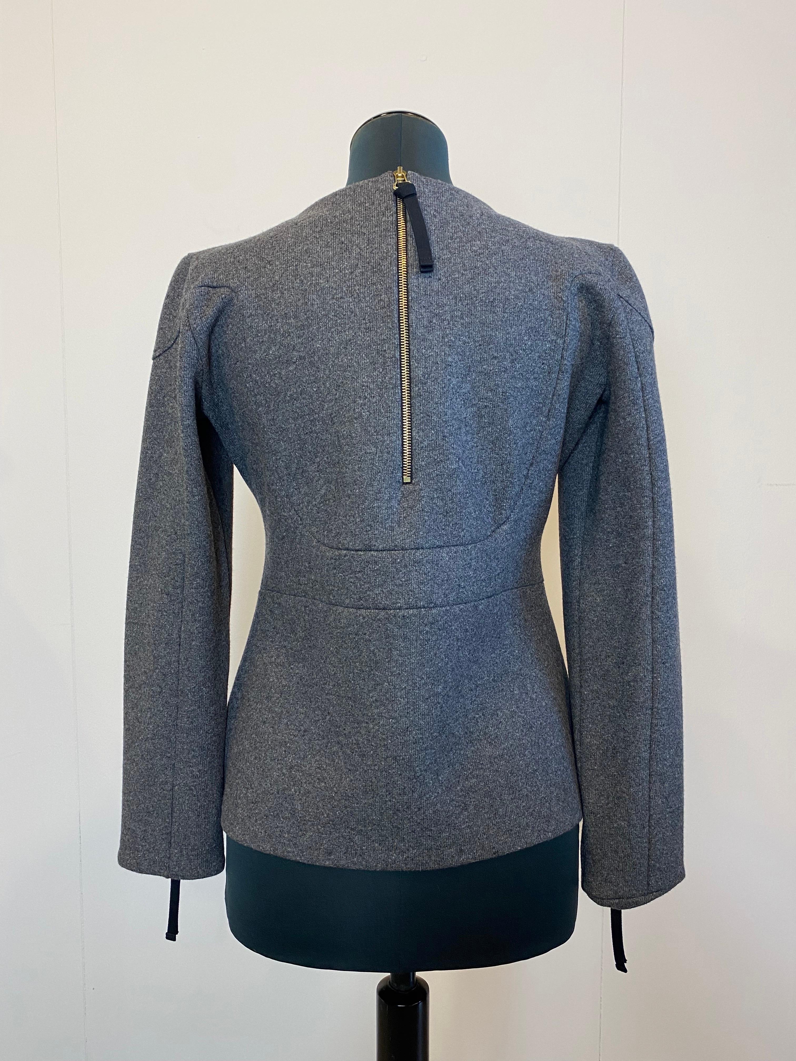 Camicetta di Marni in lana grigia con zip sulla schiena e alla base delle maniche.
La camicetta è in buone condizioni.
Lunghezza 60 cm 
Spalle 42 cm 
Petto 51 cm 
Manica cm 59 
Taglia 42