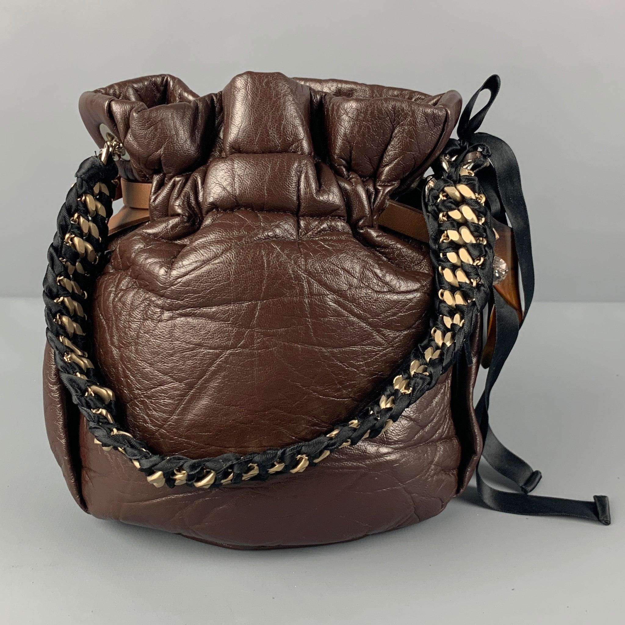 MARNI handbag comes in a brown wrinkle leather featuring a charm detail, woven handle, and a adjustable strap closure. Comes with dust bag. Made in Italy.Very Good
Pre-Owned Condition. 

Measurements: 
  Length: 7.5 inches  Width: 3 inches  Height: