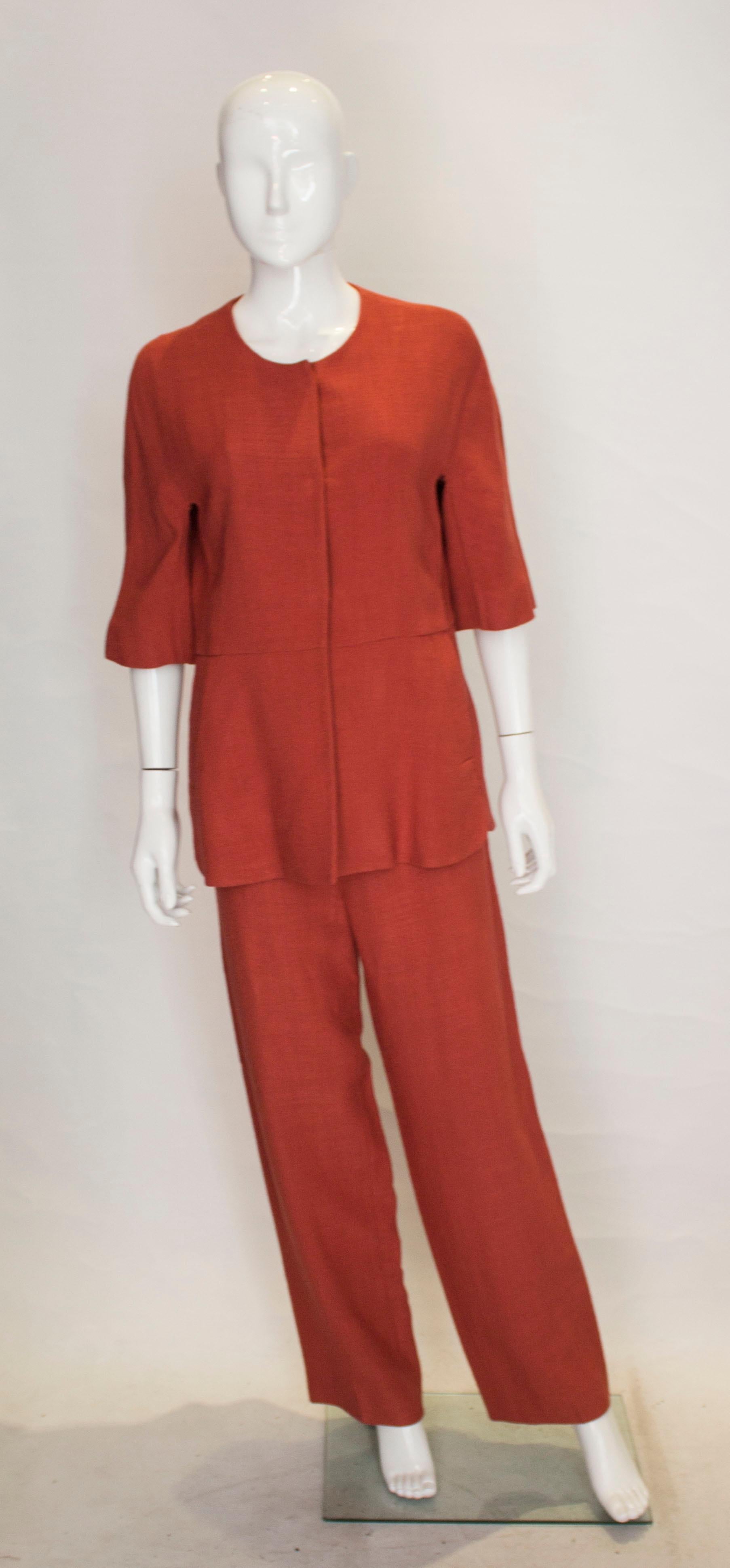 A chic trousers/pant suit for Fall by Marni. The top is marked a size 44 , and has a popper front opening. It has short sleaves, a lined peplum and two pockets. 
The trousers  are marked size 42, have a front zip opening, and inside leg measuring