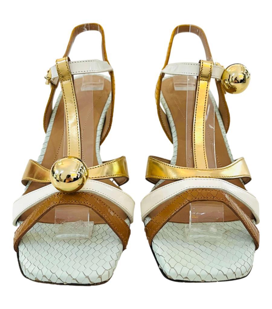 Marni Colour-Block Snakeskin Embossed Leather Sandals
White heels with strappy design in brown, gold and yellow detailed with snakeskin embossed accents.
Featuring gold ball embellishment to the centre of one shoe, and to the side of the