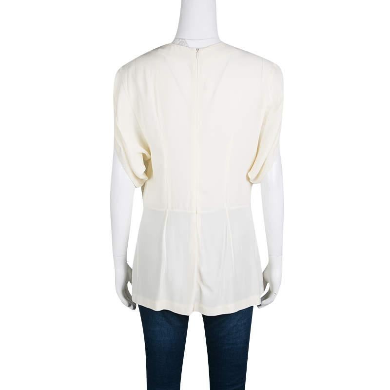 Pleated along the upper front defining the neckline, this cream-colored tunic from Marni is designed with hints of modern feminity. It has relaxed short sleeves with cut out details and is secured with a concealed zip closure.

