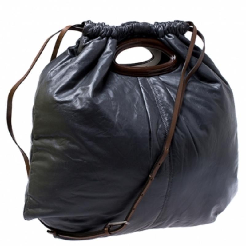 This wonderful Marni design is made from Nappa leather flaunting a dark grey shade. The bag has a slouchy shape with a drawstring closure that secures the nylon interior. It is complete with a shoulder strap and an in-built handle cutout.