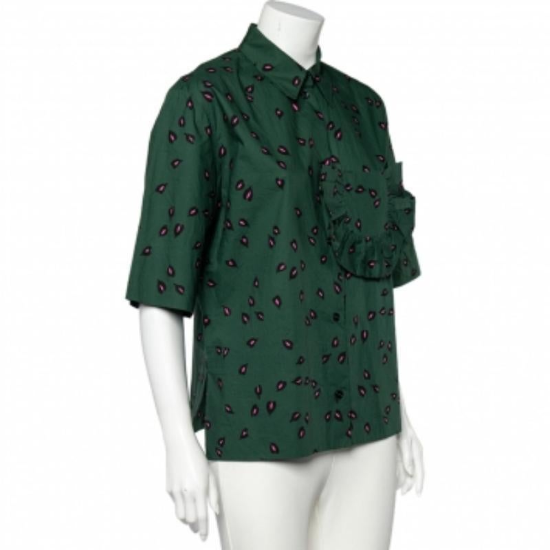 Revamp your designer collection by adding pieces like this shirt. This shirt is created using green printed cotton fabric with a ruffled trim pocket detail added on the front. It displays a button front feature and collared details. Pair this shirt