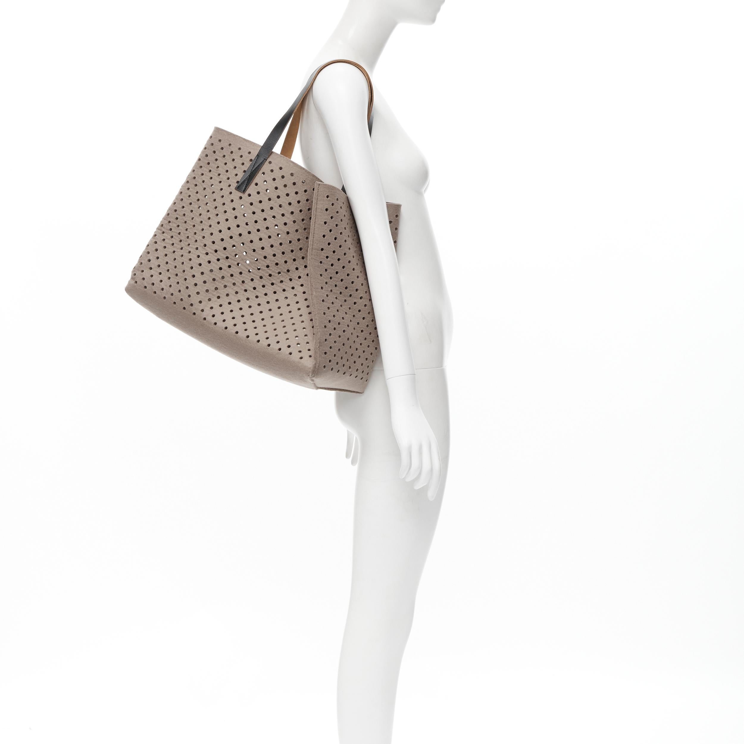 MARNI grey perforated heavy wool felt asymmetric tote bag 
Reference: CELG/A00021 
Brand: Marni 
Model: Perforated wool tote 
Material: Wool 
Color: Brown 
Pattern: Solid 
Extra Detail: Removable small pouch at lining. 
Estimated Retail Price: US