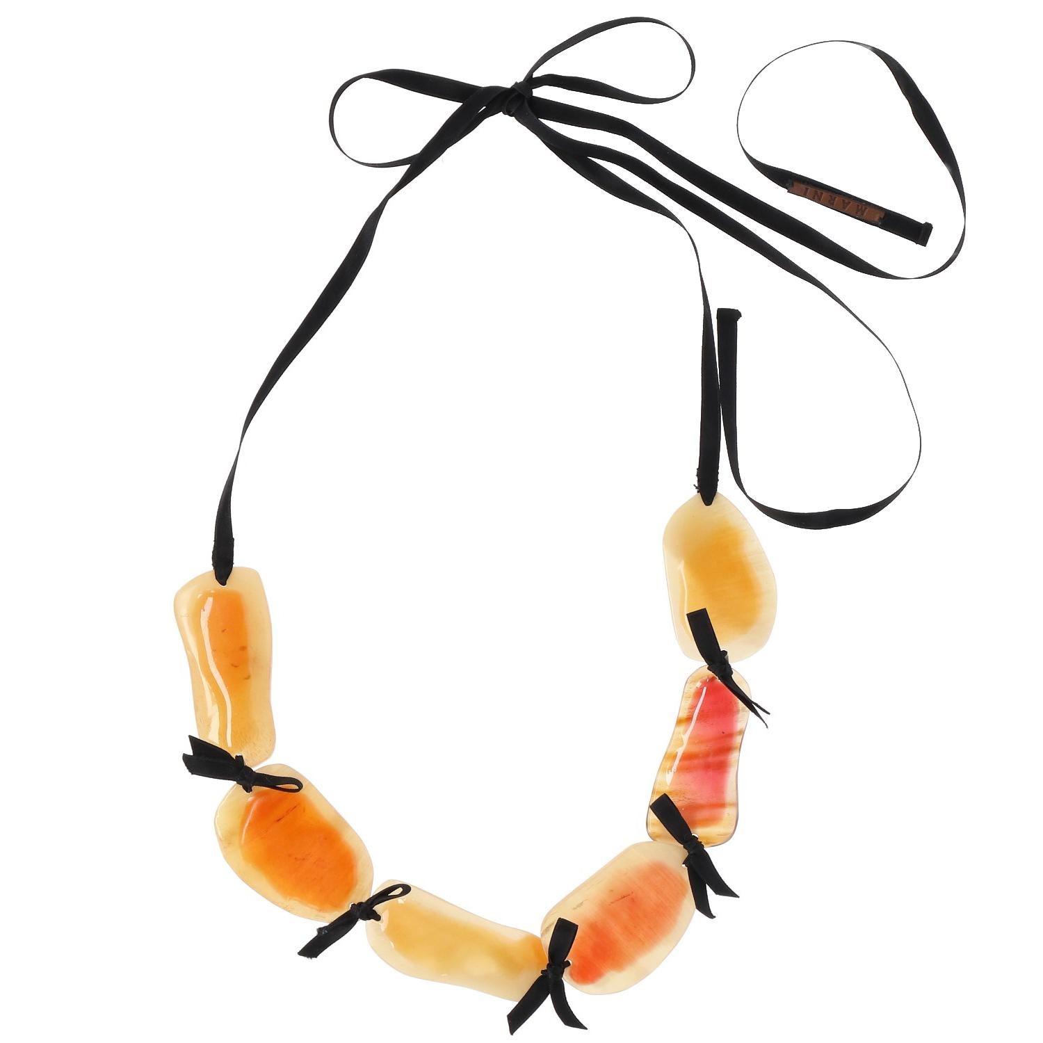The fancy and stylish Marni necklace is made by irregular horn elements covered by orange and yellow resin and tied by the black satin lace.  Original dust-bag and packaging included. 
Shipping outside EU is not possible.

Length section horn